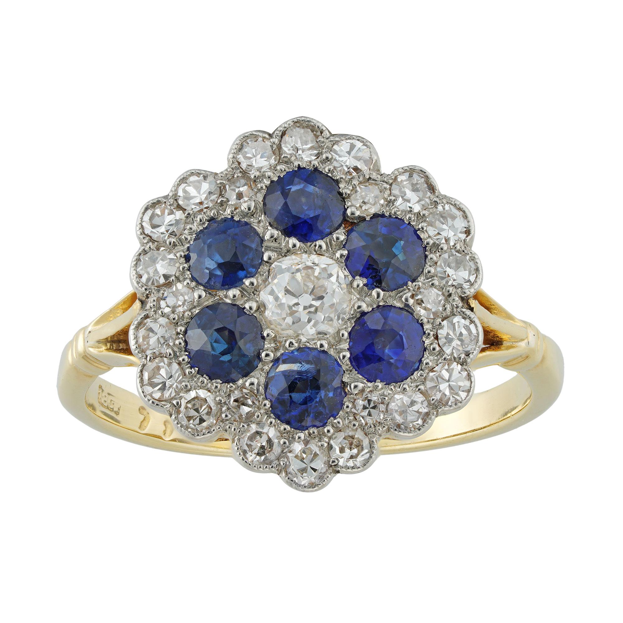 An early 20th century diamond and sapphire cluster ring, the central old European-cut diamond estimated to weigh 0.2 carats, surrounded by six round faceted sapphires estimated to weigh 0.6 carats and embellishes with twenty-four small Swiss-cut