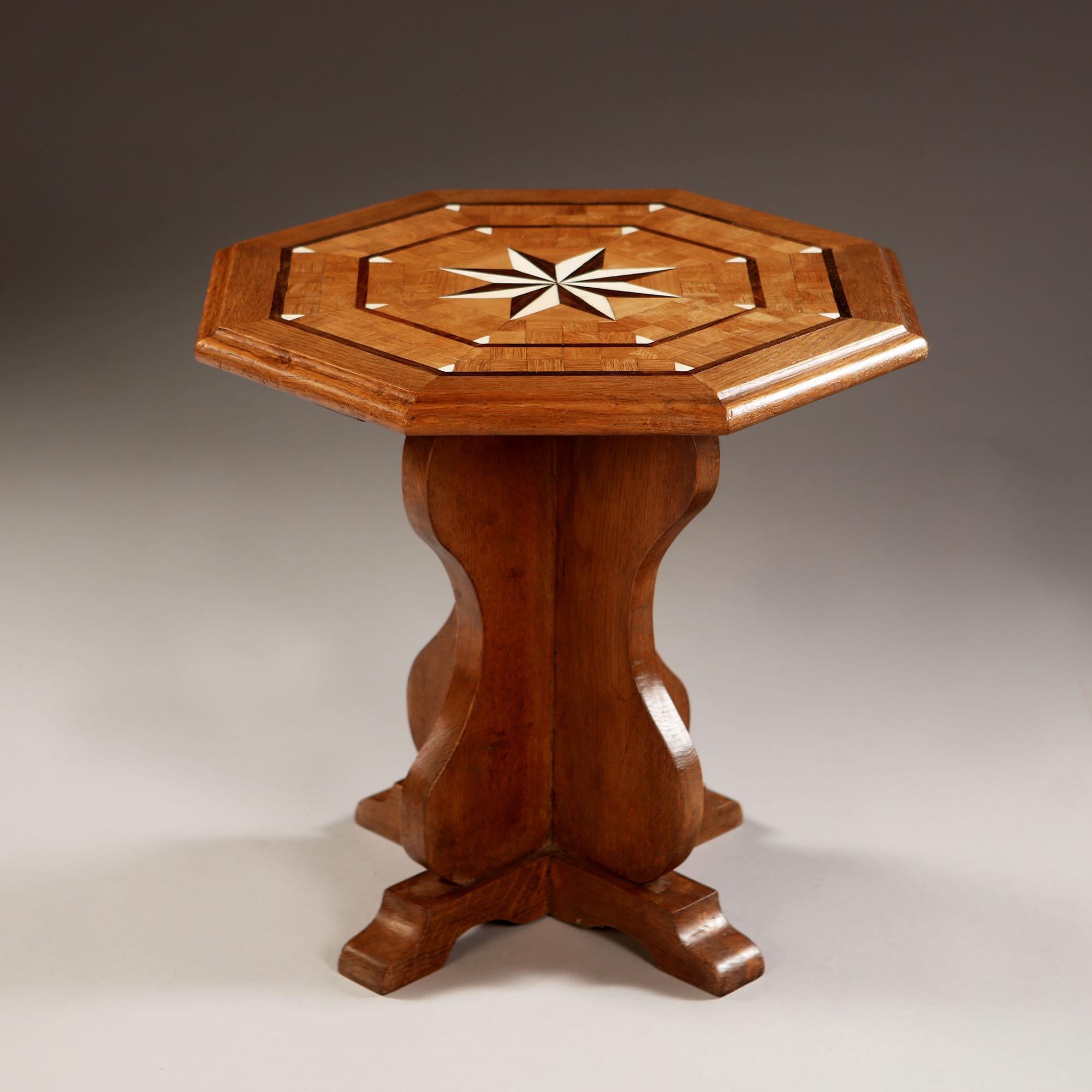 An early 20th century English hexagonal oak occasional table with bone and palm wood inlay, with geometric star design to the top.