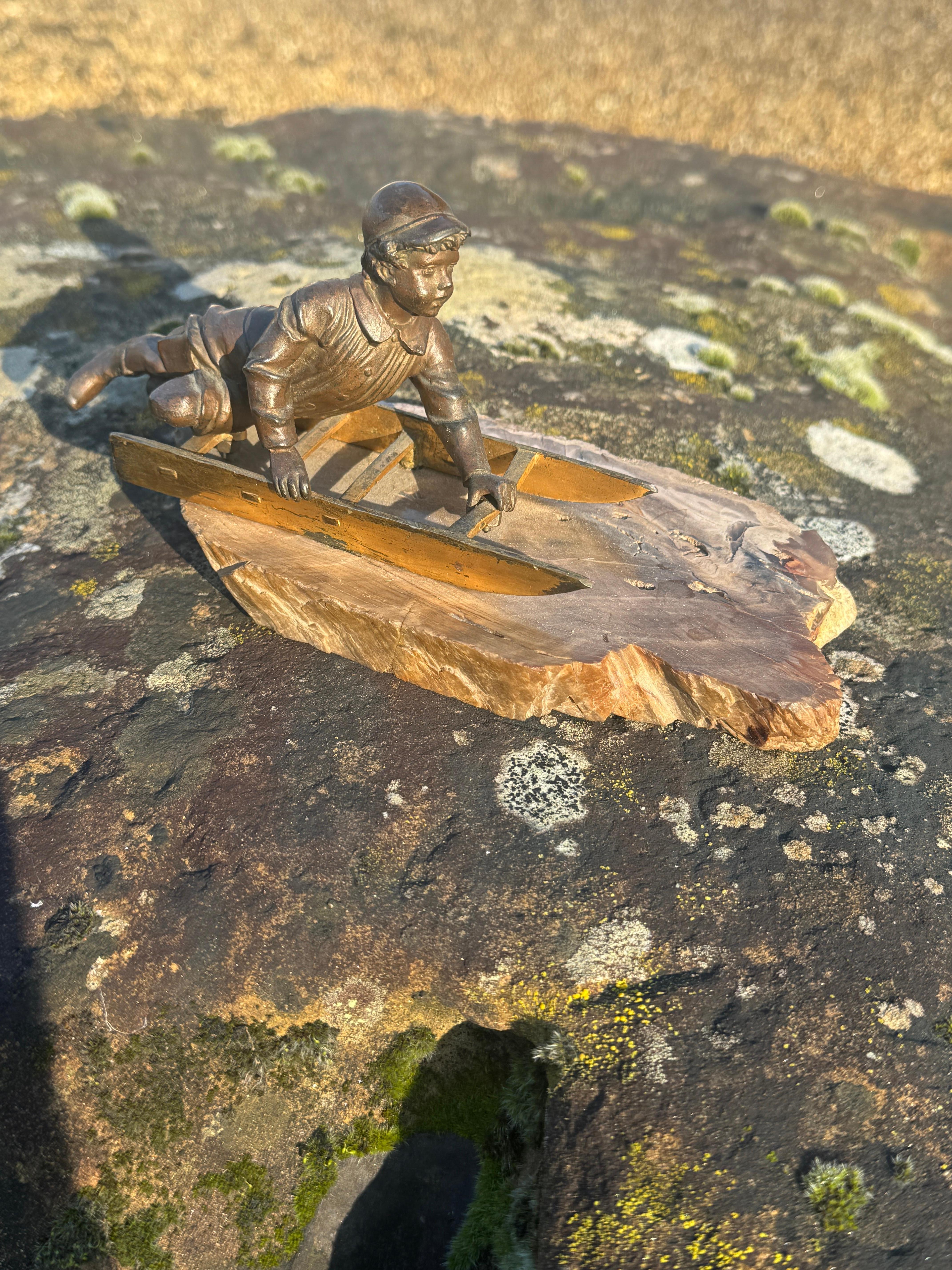 Questa affascinante figura in bronzo dell'inizio del XX secolo raffigura un ragazzo in abiti invernali sdraiato sul suo slittino. È probabile che la figura sia di origine francese, anche se non presenta né una firma né un marchio di fonderia, per