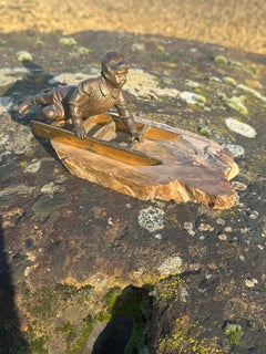 An early 20th century French bronze figure of a young boy on a toboggan