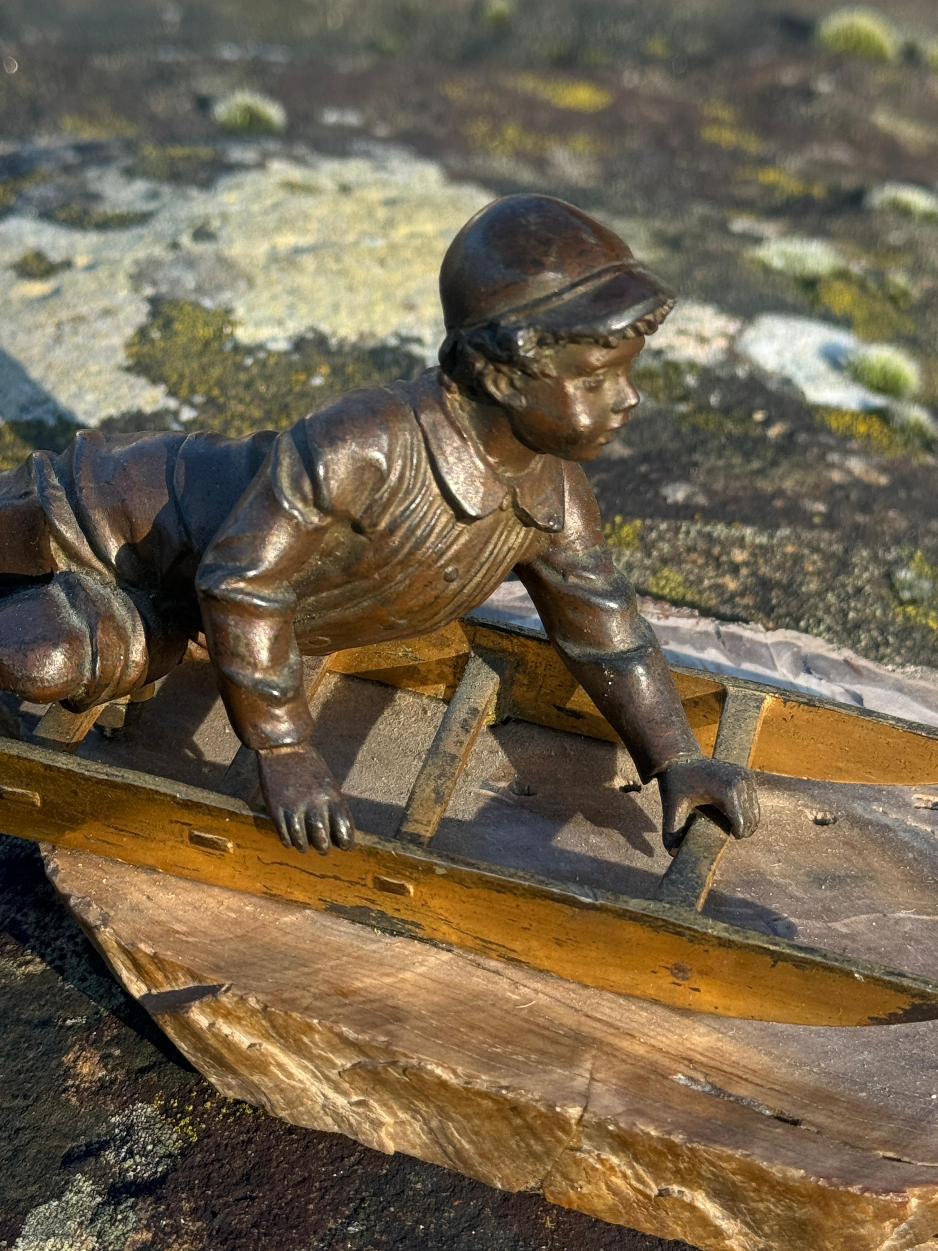 Figura in bronzo di un ragazzo su uno slittino, risalente all'inizio del XX secolo. In condizioni buone in vendita a Henley-on-Thames, Oxfordshire