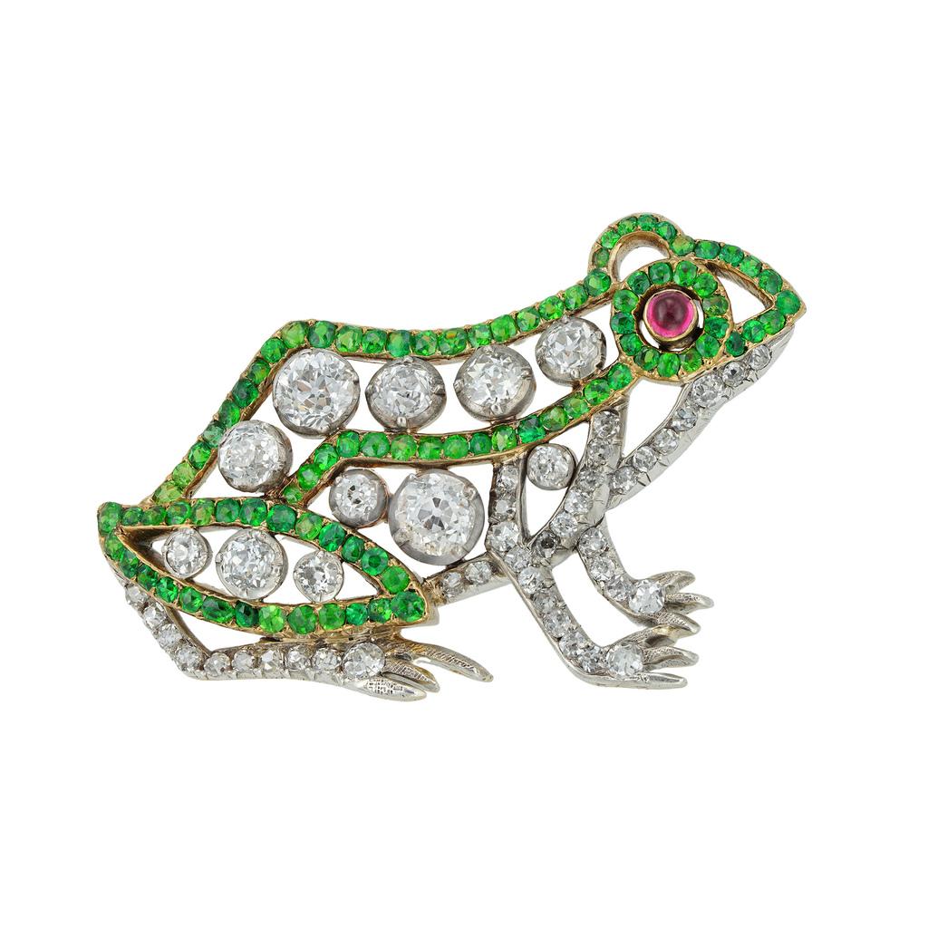 An early 20th century French frog brooch, set with old European-cut diamonds and demantoid garnets, with a round cabochon-cut ruby eye, the diamonds estimated to weigh 2 carats in total, all set in silver and yellow gold, bearing French gold eagle's