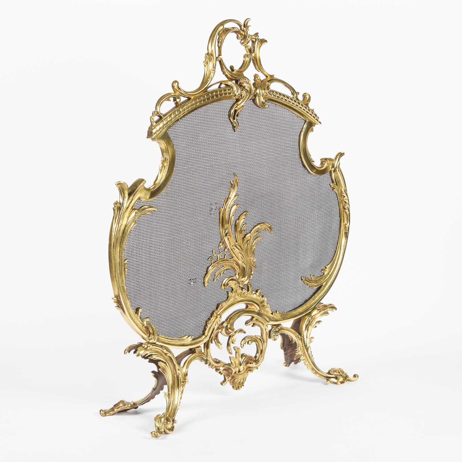 An early 20th century French Louis XV style gilt brass fire screen.

With black mesh spark guard.

