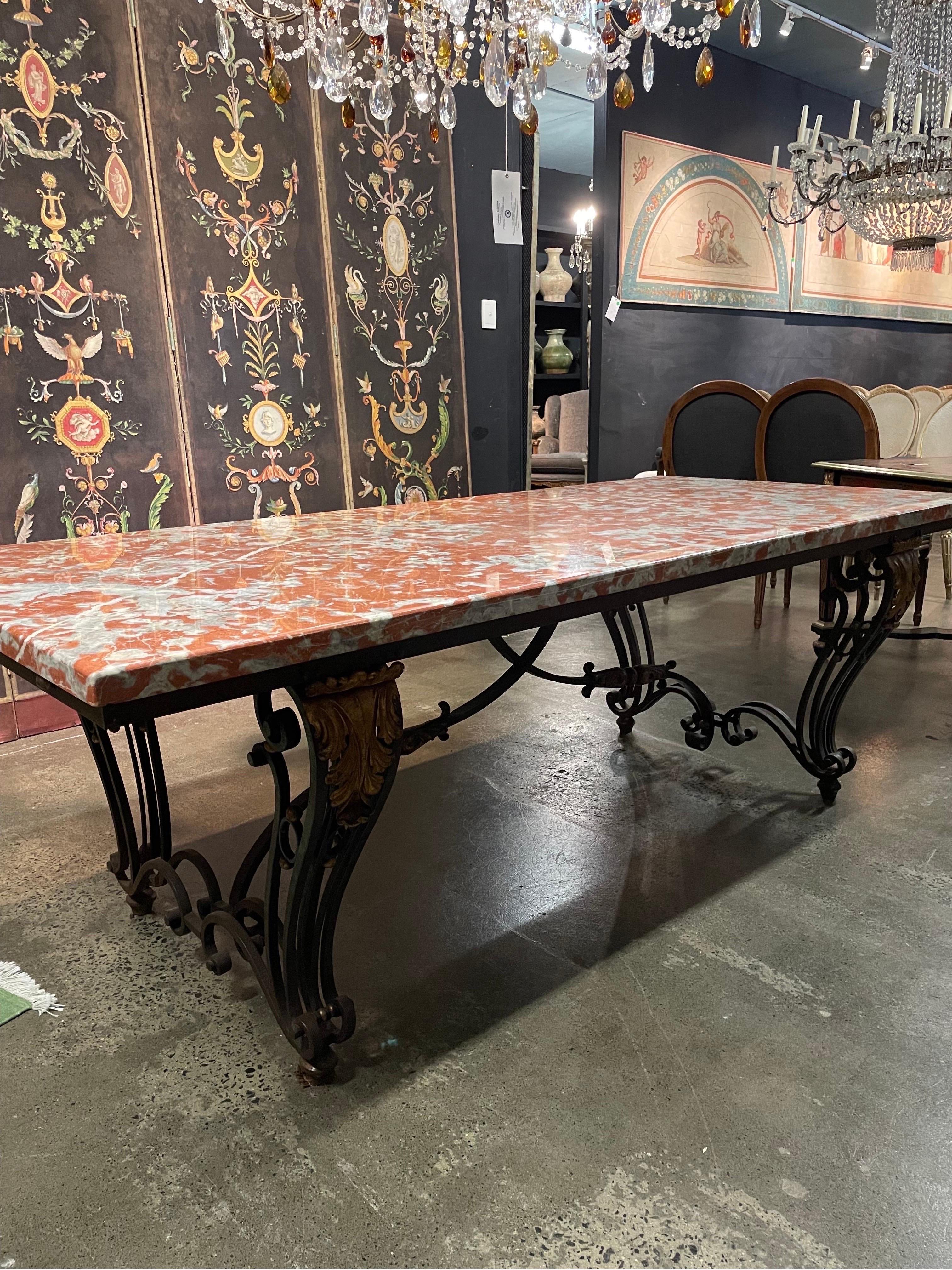 An Early 20th Century French Orange Marble-Top Table On Wrought Iron Base

The orange et gris marble top over wrought iron base with pair of cabriole scroll legs, each with gilt anthemion capital and double s-scroll stretchers joined by a central