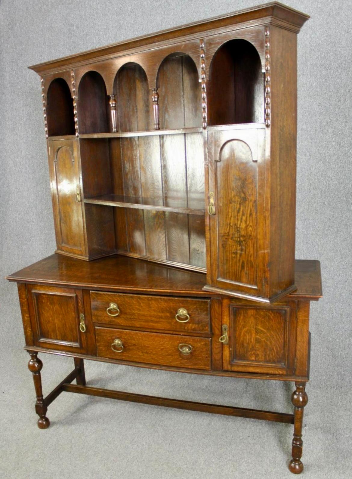 A very attractive early 20th Century Oak dresser and rack. Lovely rich colour.

The plate rack has a boarded back, galleried centre, flanked by two cupboards with the base housing 2 central draws, raised on turned frontal supports, tied by flat