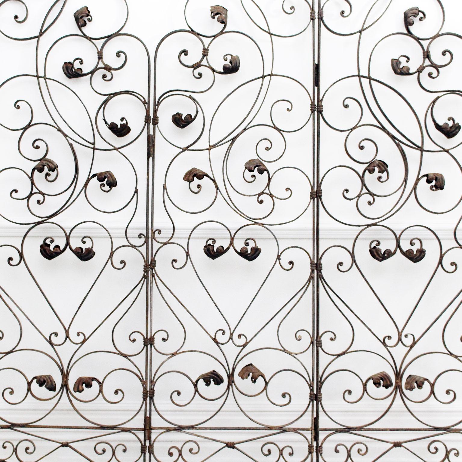 This tremendously ornate metal room divider or garden screen is decorated throughout with swirls and leaves. There are three sides, which can be arranged either to stand freely or which would also look great flat against the wall behind a table or