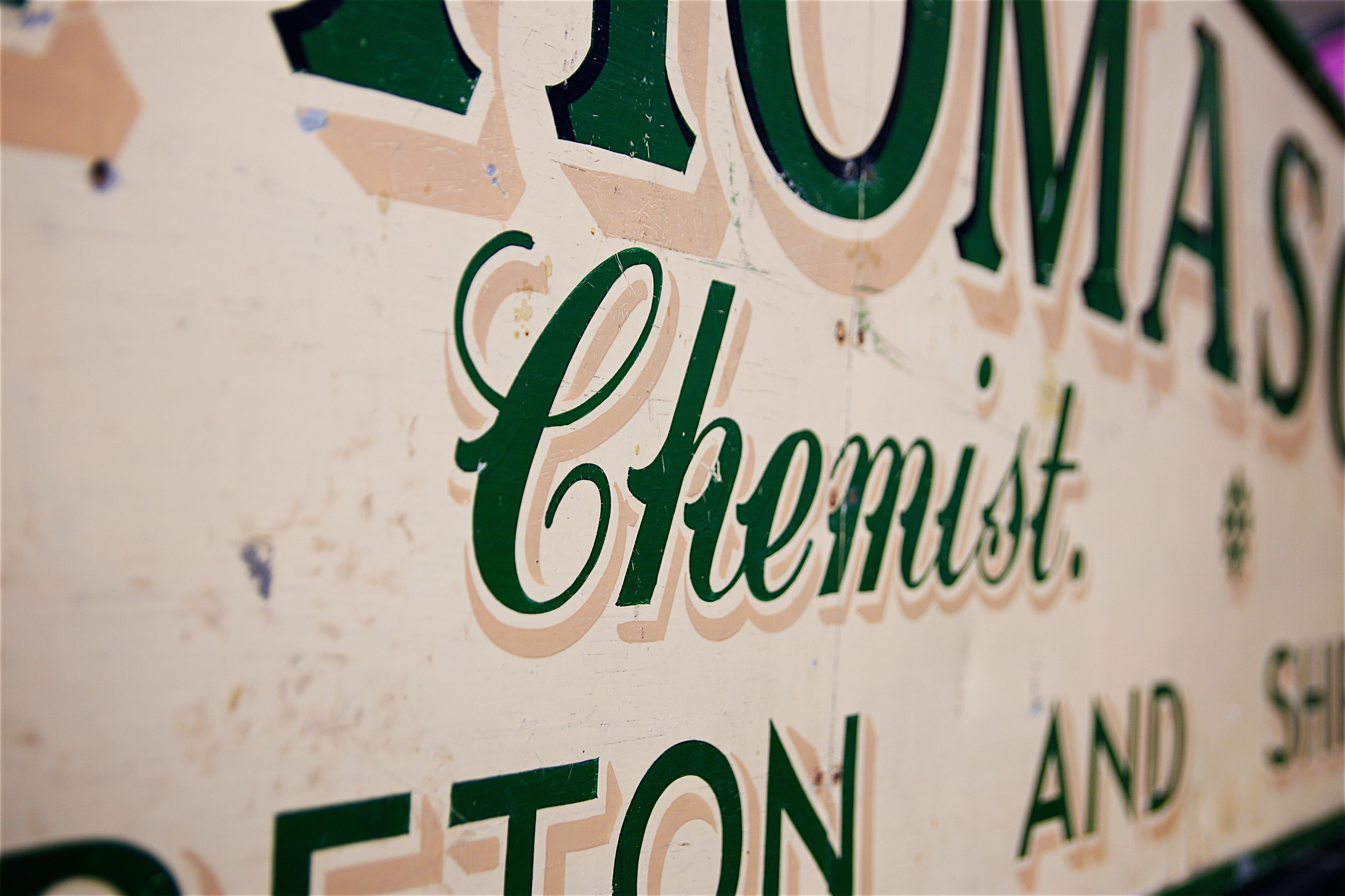 A 20th century painted metal and wood shop fascia sign for “A.F. Thomason, Chemist, Campden, Moreton and Shipston” painted green on cream.