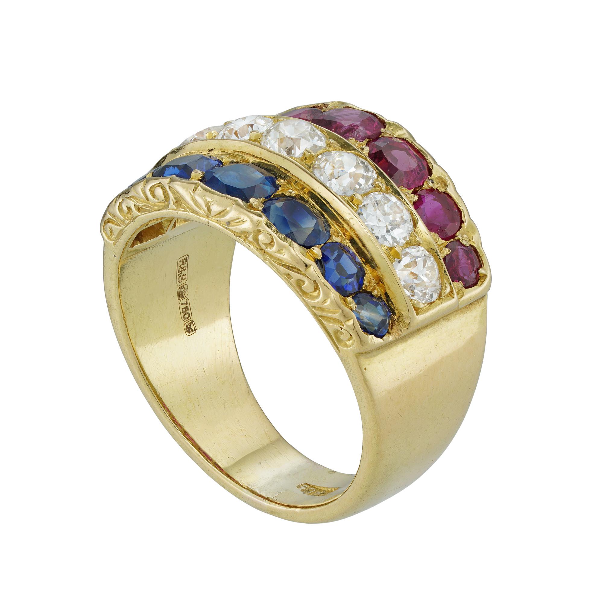 An early 20th century ruby, diamond and sapphire ring, to the centre seven old European-cut diamonds estimated to weigh 1.3 carats in total, set between a row of seven faceted sapphires graduating from the centre and estimated to weigh 1 carat in