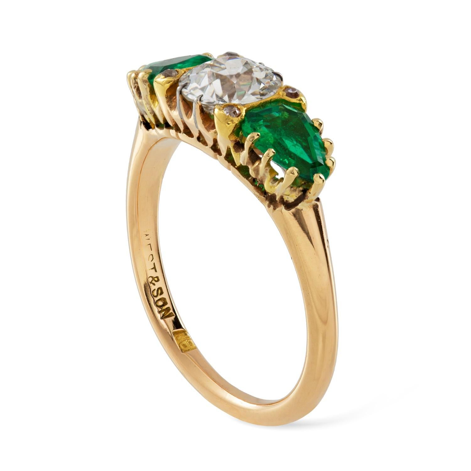An early 20th century three stone emerald and diamond ring, the old European-cut diamond estimated to weigh 0.8 carats, set between two shield-shaped emeralds estimated to weigh 0.9 carats in total, accompanied by GCS Report stating to be of