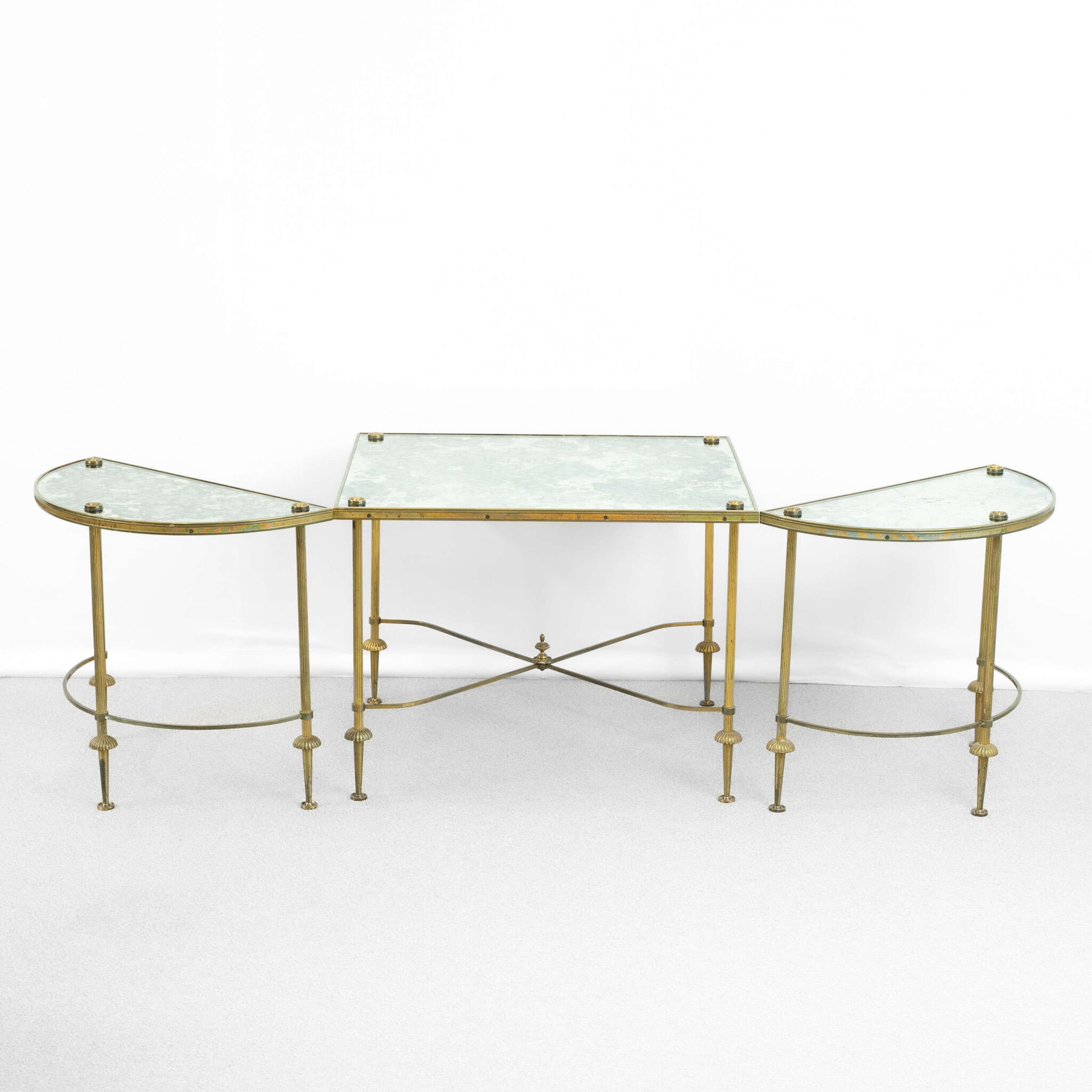An early 20th Century tripartite ( 3 part ) verre églomisé, Maison Baguès coffee table .
Reeded brass legs with fluted detail and a decorative centre finial.
Useful demi lune side tables, which can be used separately or in conjunction with the main