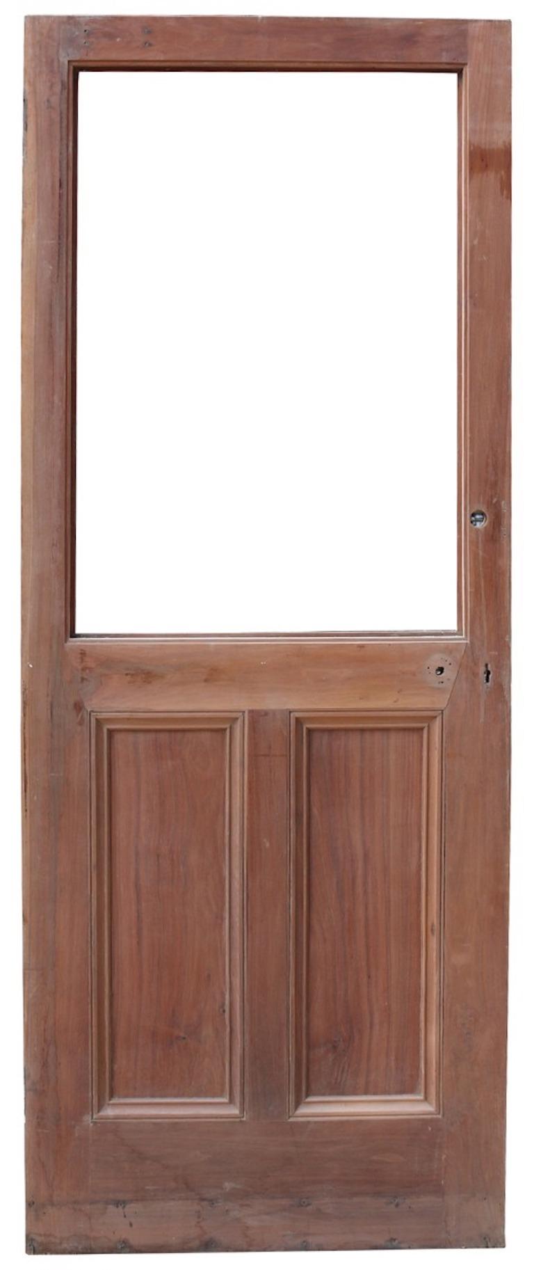 Eine alte Tür aus massivem Nussbaumholz mit Platz für eine Glasscheibe.