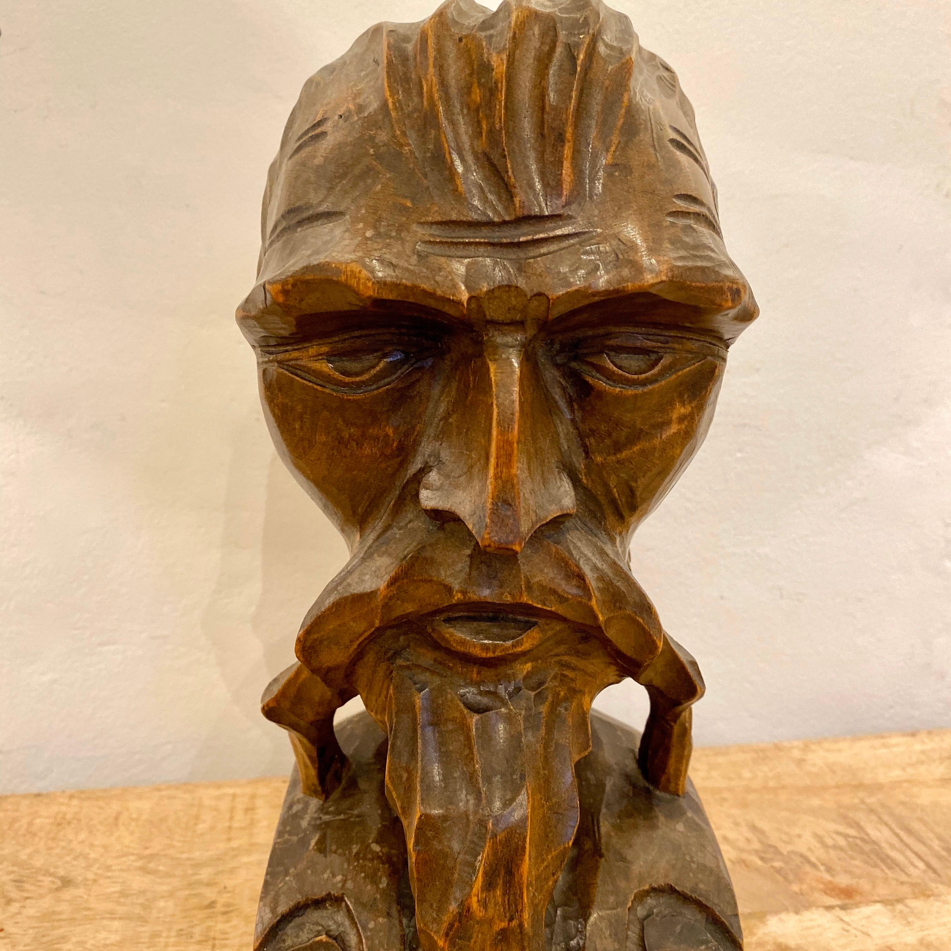 An interesting early 20th century carved bust of a bearded gentleman. Nicely executed in what looks like beech. The gentleman with a furrowed brow and sweptback hair, a large handlebar moustache and a goatee beard. Standing on a scooped base. It