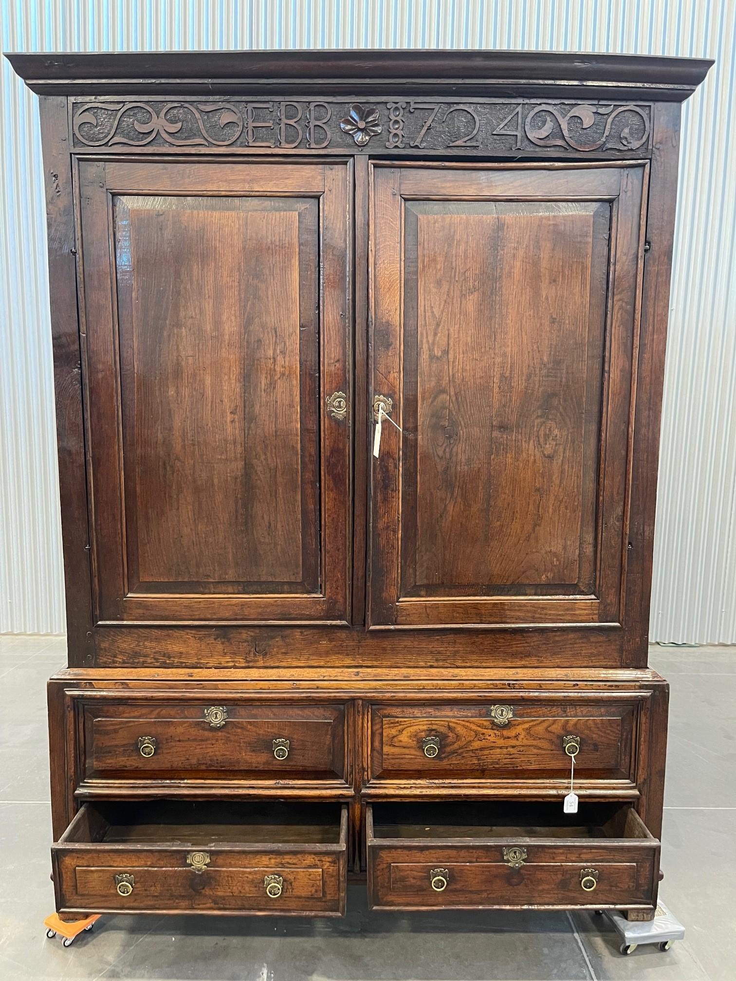 AN EARLY OAK CLOTHES PRESS, BEARING THE DATE 1724
Carved into the frieze ‘EBB 1724’. 
Condition Report: This appears to have had some adaptions over the years, there is a hanging rail fitted to the interior, shelves have probably been removed to