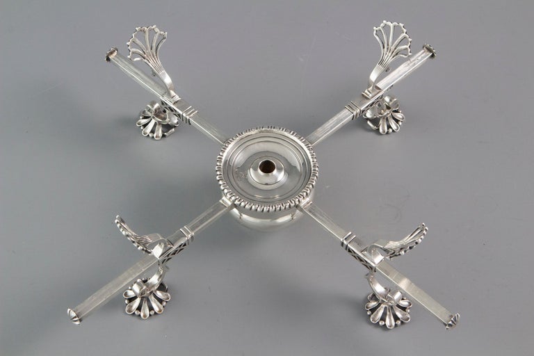 An early George III articulated silver dish cross, London 1766. The raised central bulbous spirit burner is topped with a lid decorated with a gadroon border. Rotating cross-section arms and adjustable cast shell decorated dish holders and