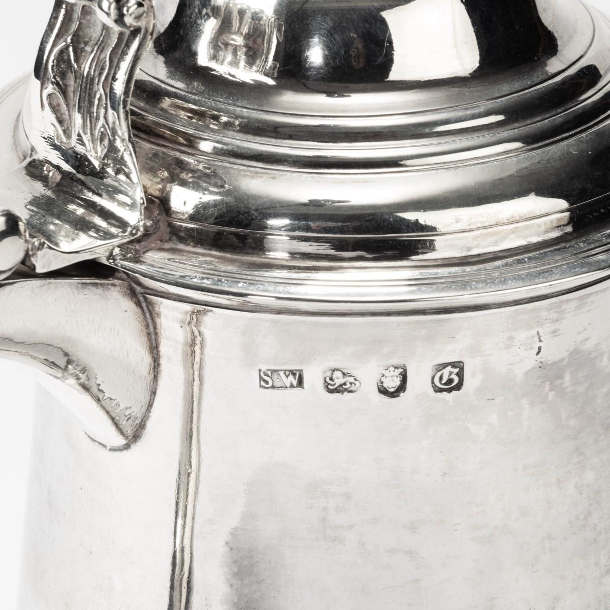 An early George III silver tankard, the cylindrical body with an applied S-scroll handle with a foliate thumb piece attached to a high, domed cover, clear assay stamps for SW, London, 1762-1763.