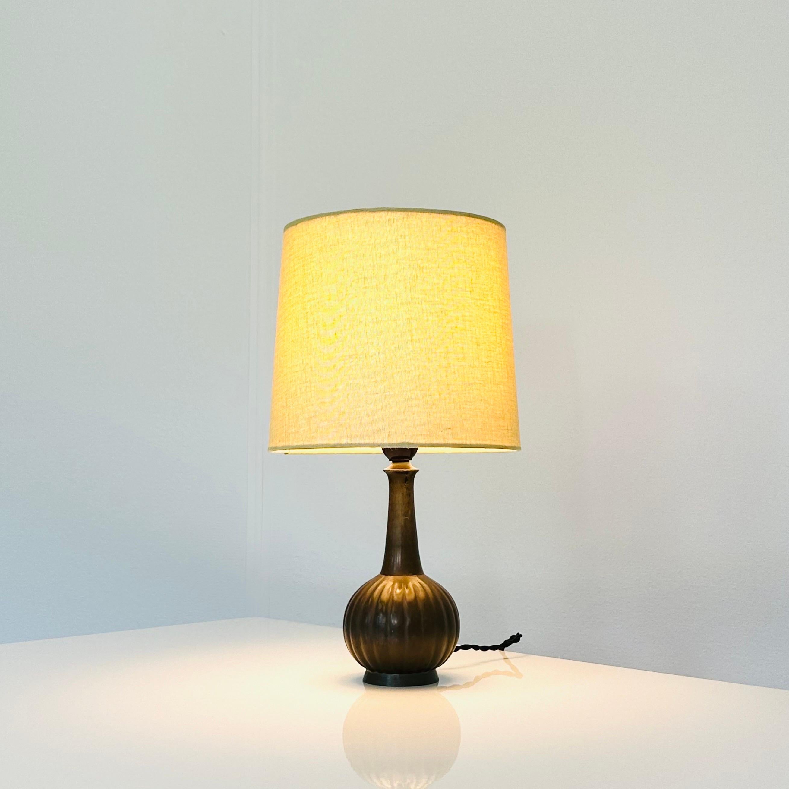 An early, exquisite Just Andersen table lamp. A rare find for collectors and design enthusiasts.
* A metal lamp with a round base and vertical lines with a beige coloured fabric shade
* Designer: Just Andersen
* Model: D140 (stamped ‘Just