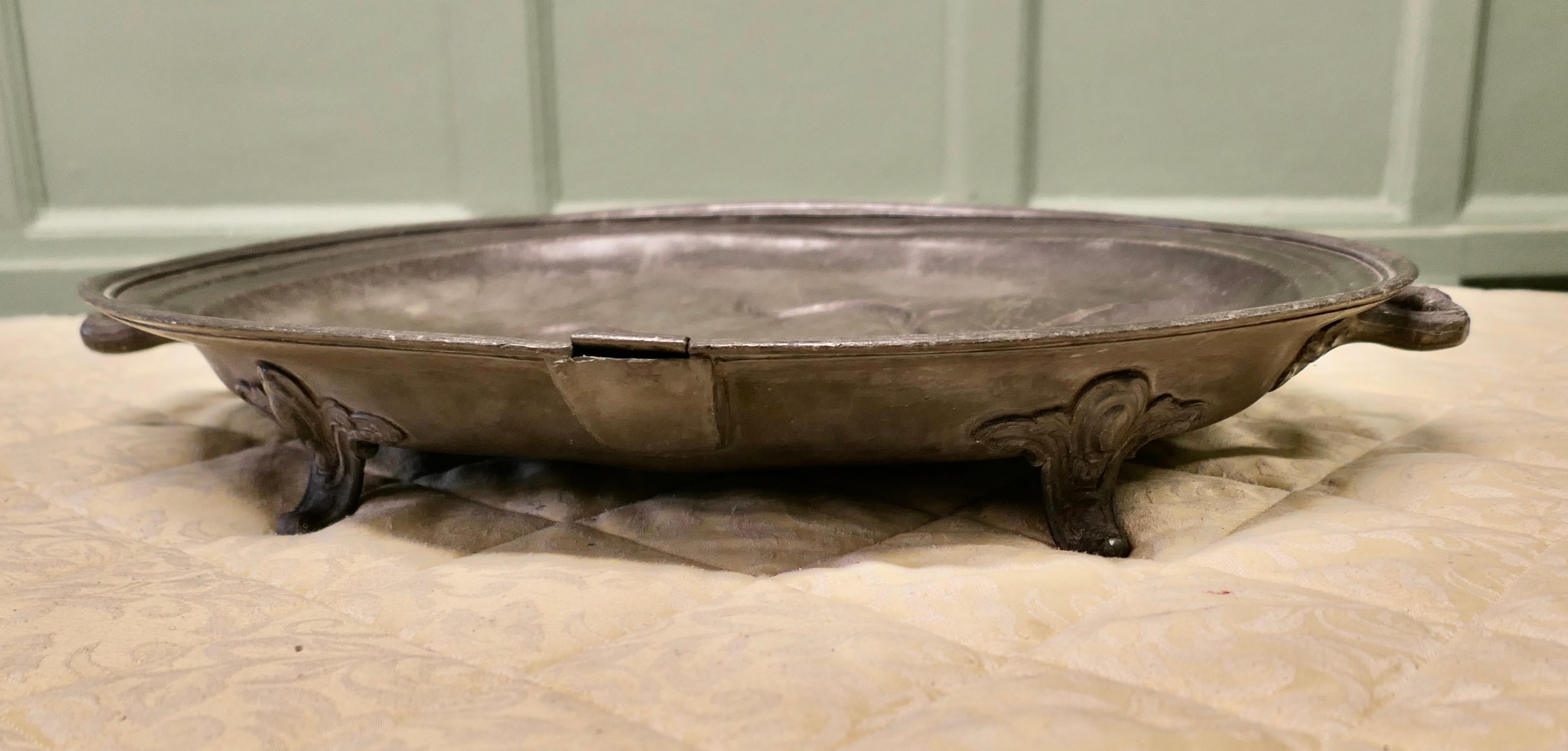 An Early Large Pewter Meat Platter by Shaw and Stewart 

The platter stand on simple strong feet, it has robust solid cast handles, and on the top is the access to the reservoir for hot water to keep the meat warm. The whole must have been