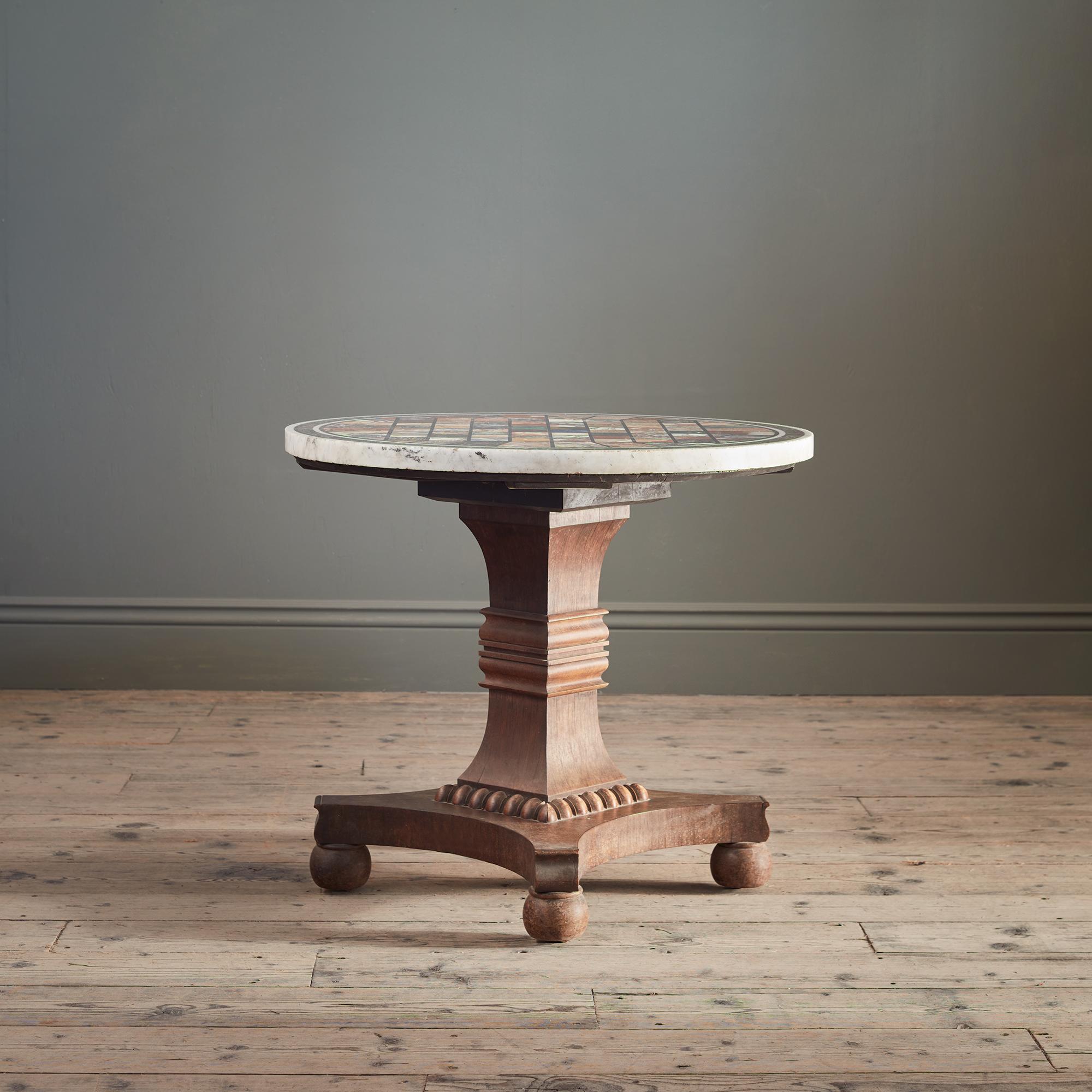 The powerful rosewood base, carved with waisted and knopped square, on a quatrefoil base on bun feet, supports a magnificent circular specimen marble top; extensive Grand Tour marbles are displayed in a checkerboard pattern, with sixty four examples