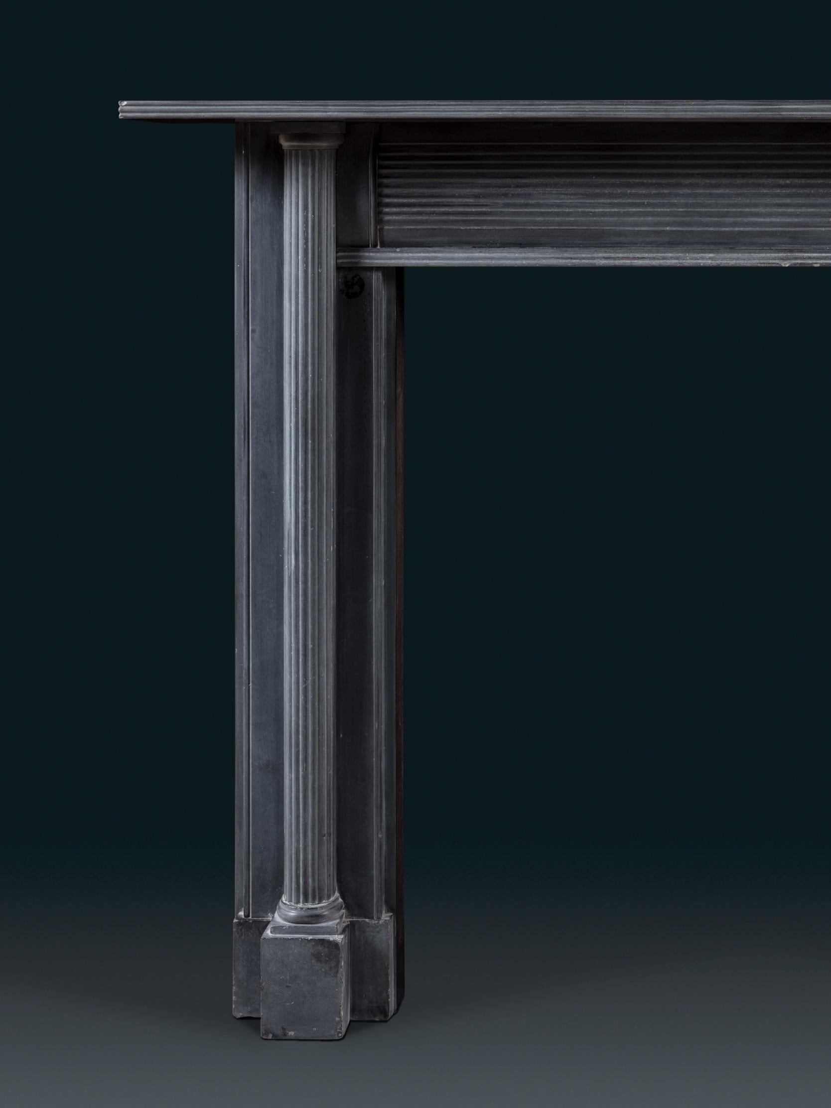 Chimenea irlandesa de finales del siglo XVIII, de piedra caliza azul, con columnas dóricas y friso de junquillos. El lenguaje arquitectónico sencillo de esta chimenea recuerda al innovador diseño neoclásico de chimeneas de Soane. Esta pieza residió