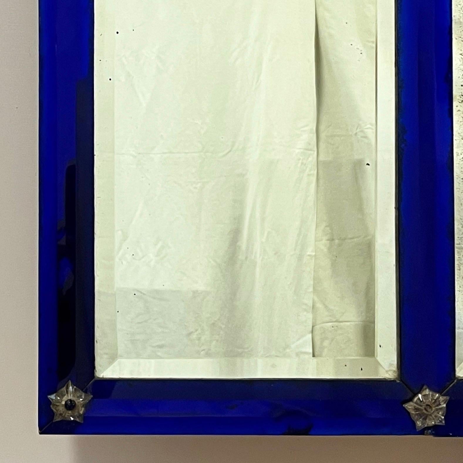 Un très élégant miroir français à trumeau avec une section centrale arquée flanquée de deux plaques rectangulaires et d'une bordure en verre bleu empire, le tout biseauté - entrecoupé de paterae étoilées en verre.

Début du vingtième siècle
