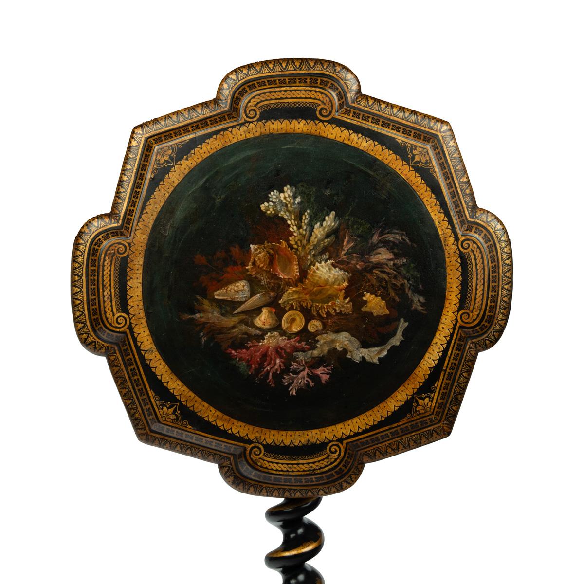An early Victorian black and gilt papier-mâché occasional table, the shaped top delicately painted with shells and seaweed within multiple gilt classical borders, all raised on a barley twist tripod support with further gilt decoration.  English,