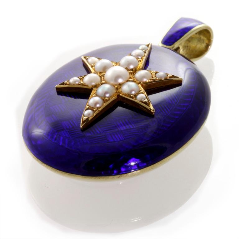 Ciondolo vittoriano in smalto blu con motivo a stella di perle e fondello a medaglione; il ciondolo ovale, circa 42x26 mm, è decorato con smalto blu e motivo a stella centrale con perle graduali verso l'esterno, 15 perle in totale, fondello in oro
