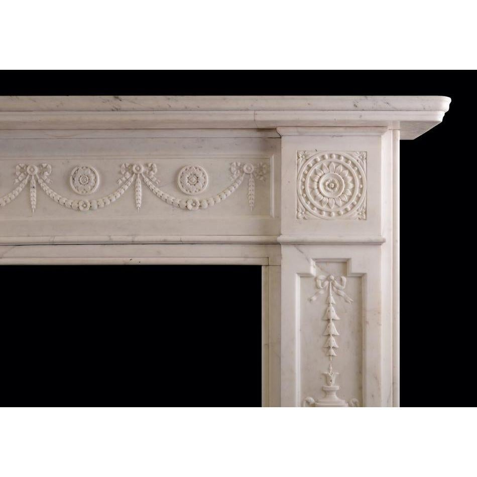 A substantial early Victorian fireplace in white Statuary marble. The jambs with finely carved urns, bellflowers and drapery, surmounted by rosette end blockings. The frieze with rosette paterae and swags throughout. Moulded shelf above. English,