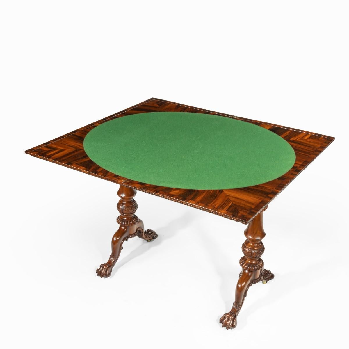 An early Victorian Goncalo Alves card table attributed to Gillows, the hinged rectangular top with bead and reel edging, the green baize (replaced) interior within quarter veneered corners, the turned, knopped end supports gadrooned and set upon two