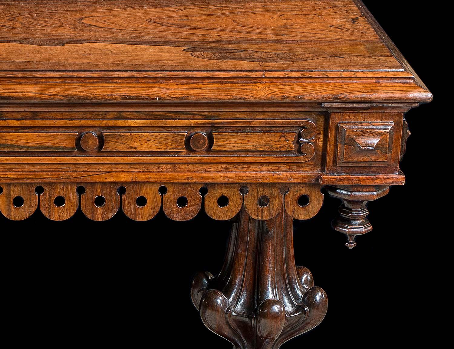 A fine early Victorian, rosewood library table in the manner of the architect and designer Richard Bridgens (1785-1846). The finely figured top, with a moulded edge above a framed carved baton and disc frieze and square paterae on each corner, is