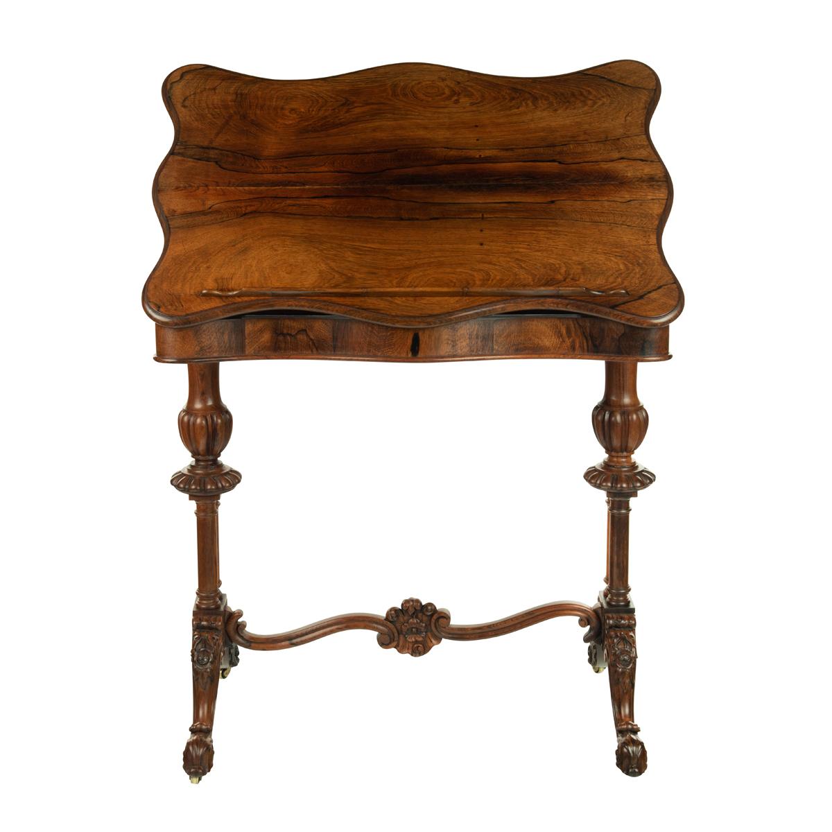 An early Victorian rosewood reading table, the shaped top hinged to form an adjustable reading slope with a ratcheted support and detachable rest, raised upon turned and flanged end supports with double columns above out splayed cabriole legs joined