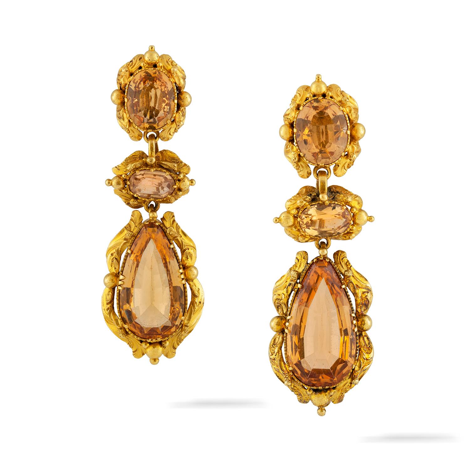 An early Victorian topaz and gold repousse suite, the necklace consisting of nine graduating from the centre oval faceted topazes, set on gold collets with repousse-work decorations, suspended by seven rows of gold trace chain, to a topaz-set clasp,