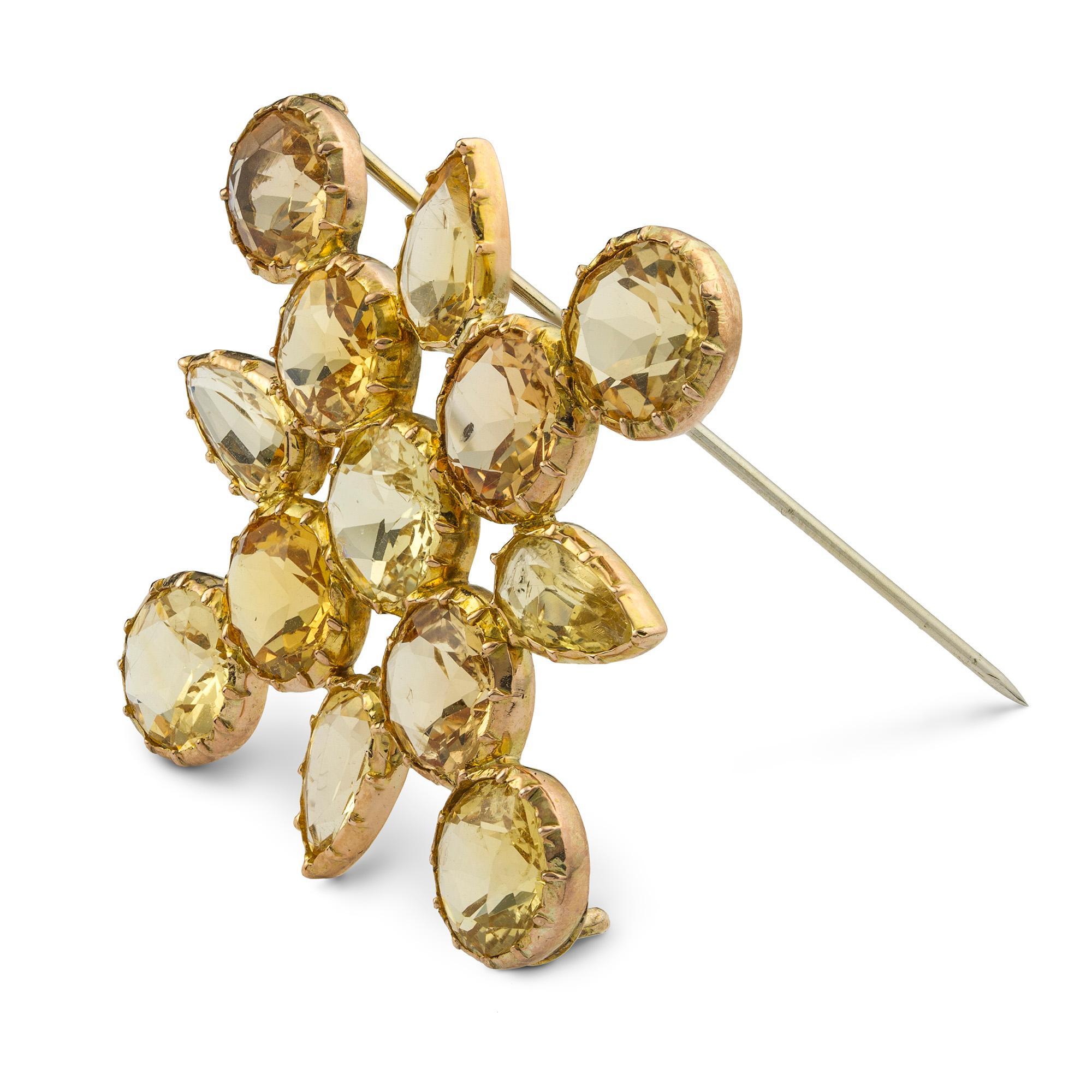 An early Victorian topaz set cross brooch, the brooch in the form of a cross with nine round faceted topazes and pear shape faceted topazes in between the topazes, estimated to weigh total of 23.5 carats, all cut down set to a gold mount with a