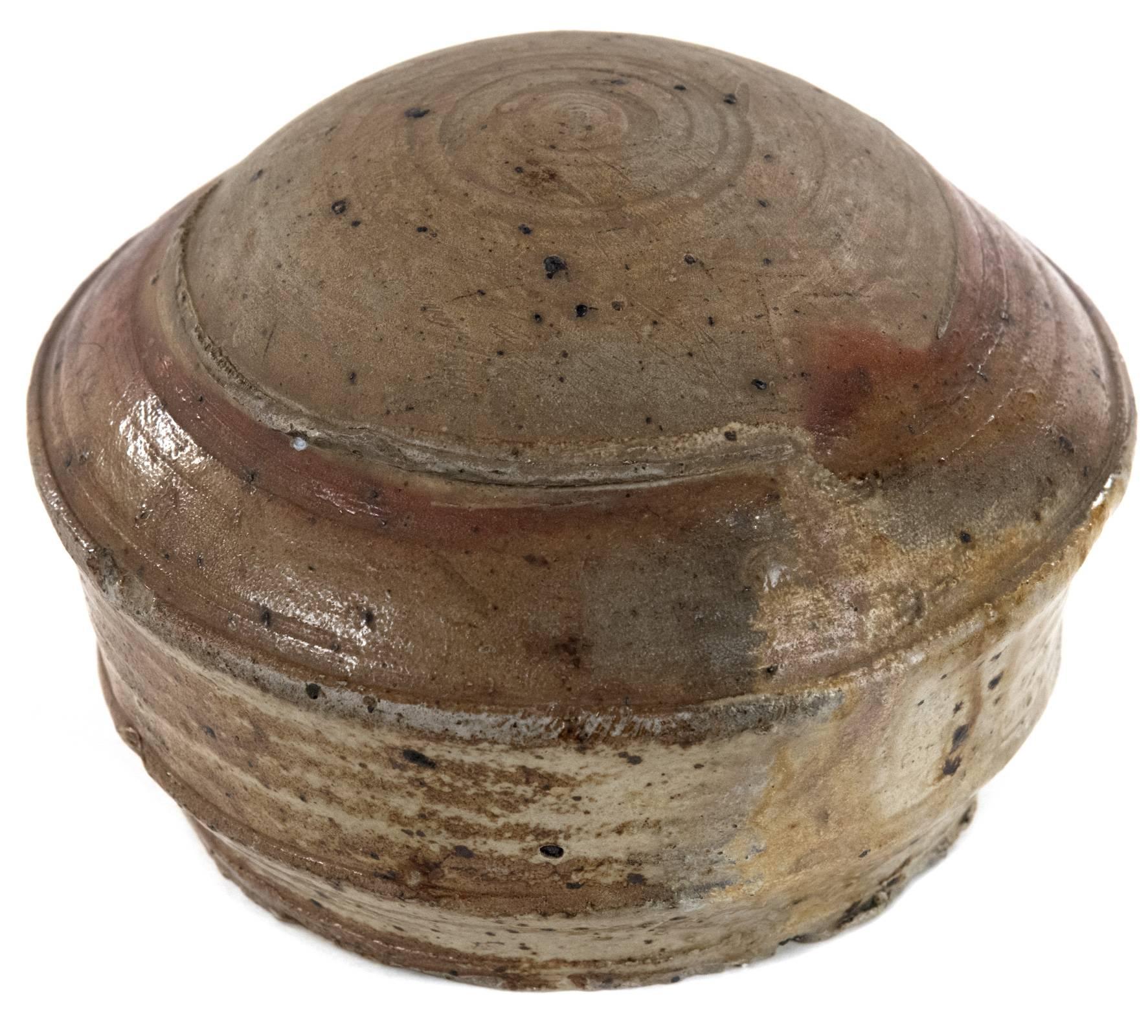 A 19th century earthenware salt celler decorated with a salt glaze, the round, domed top, reminiscent of a turtle shell, above a tapering body with a strong handle. Measures: 5 ½ x 9 x 10 inches.