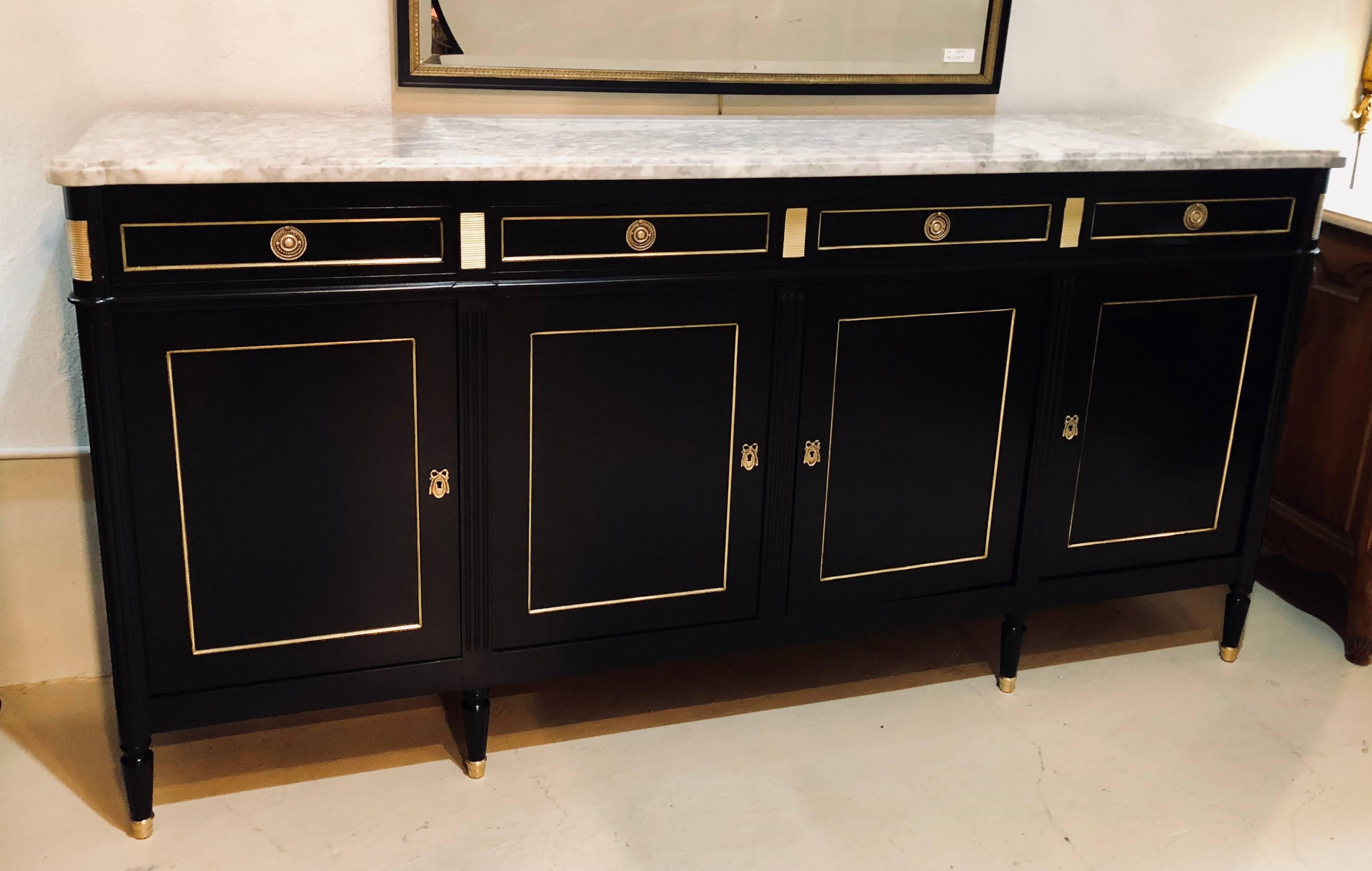 An ebonized Louis XVI style Maison Jansen fashioned sideboard or credenza. In a word, spectacular. This Louis XVI style sideboard has all the glamour and flair one would expect to see from the Hollywood Regency era. The tapering stout legs having