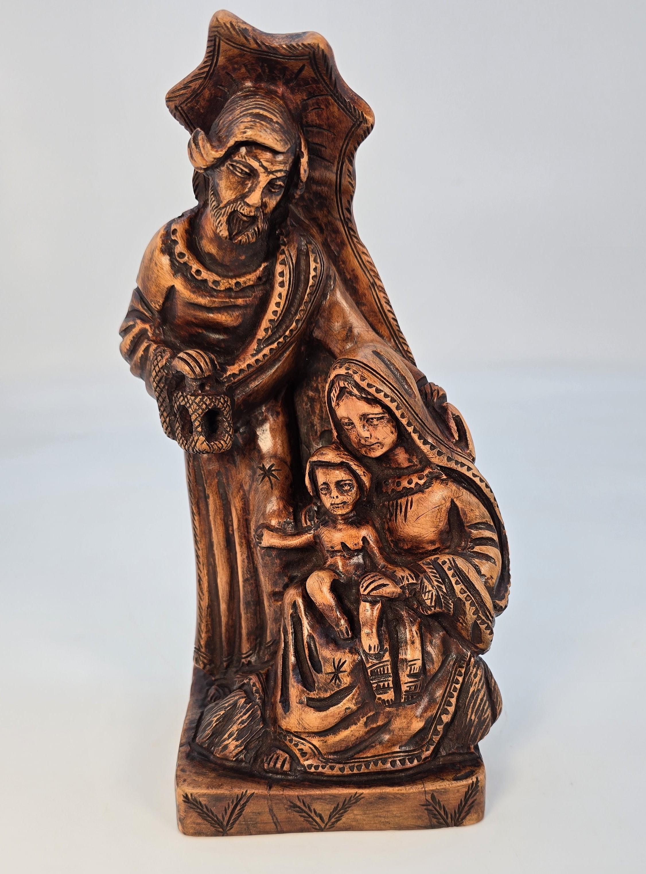 Ce superbe et rare groupe religieux italien en bois d'olivier sculpté à la main représente Jésus avec Marie et Joseph.

Joseph est debout, une lanterne dans une main, l'autre bras autour de l'épaule de Marie, qui est assise avec le jeune Jésus sur