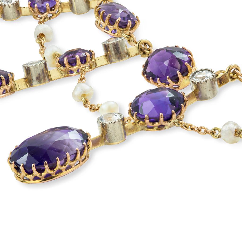 An Edwardian amethyst, diamond and pearl fringe necklace, consisting of seven bars graduating from the centre, five bars each set with two old European-cut diamonds and two amethysts, the two smaller bars each set with two amethysts, all bars