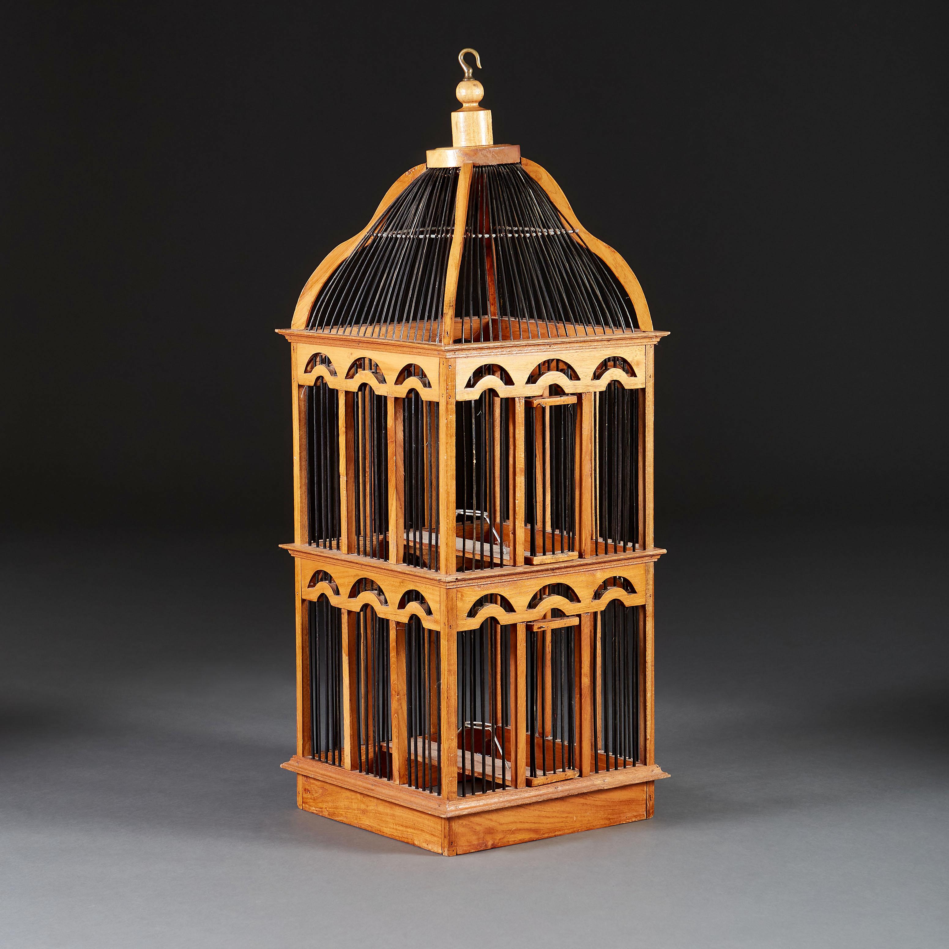 An Edwardian box wood birdcage of large scale, with ebonised bamboo caging, with arcaded formation, with two small doors to the front.