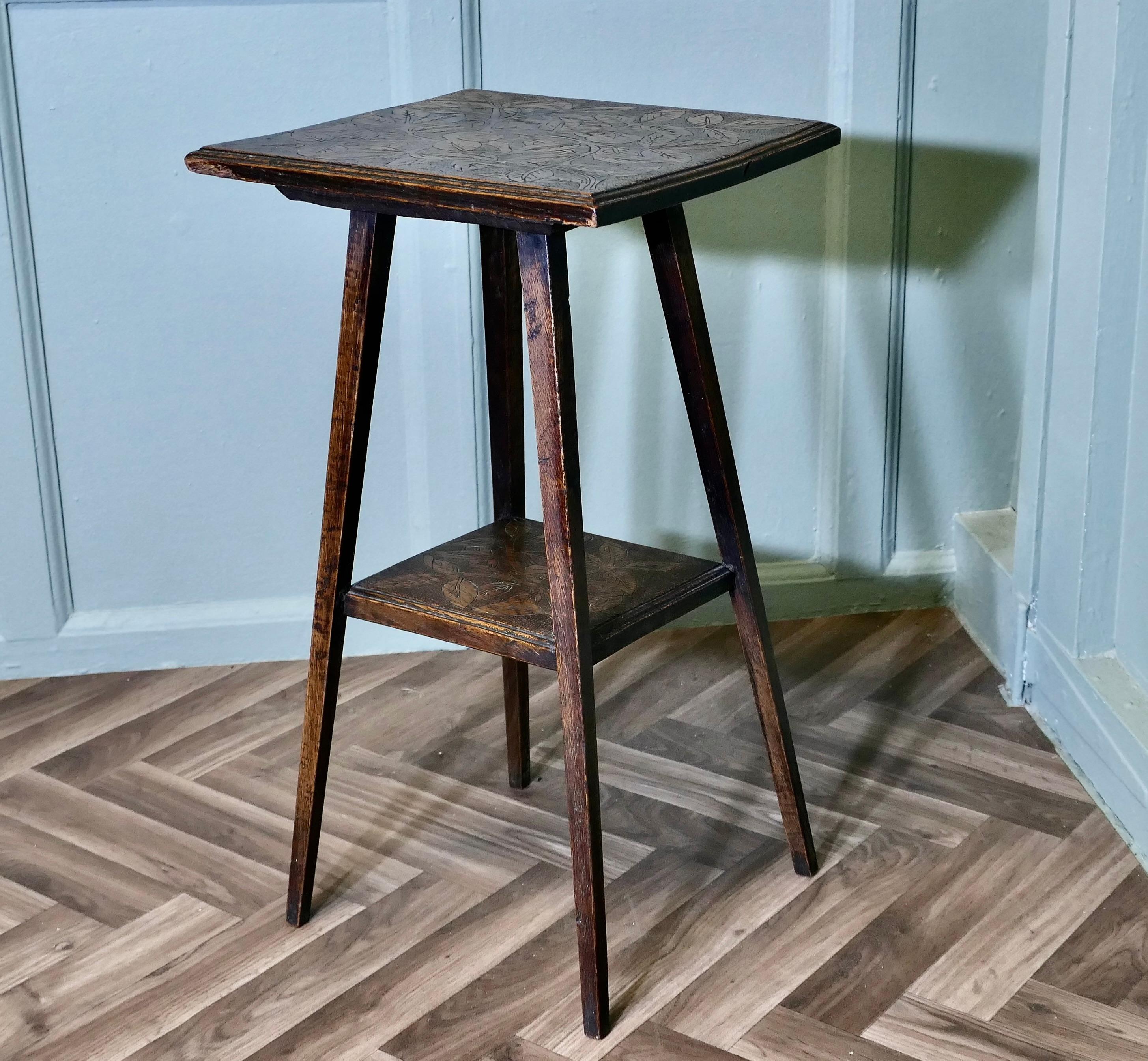 An Edwardian Carved Oak Etagere or Occasional Table

This useful little table has two tiers, the top is square with a scratch carved design of leaves and a moulded edge, the under-tier is also carved with same design, the table is set on tapering