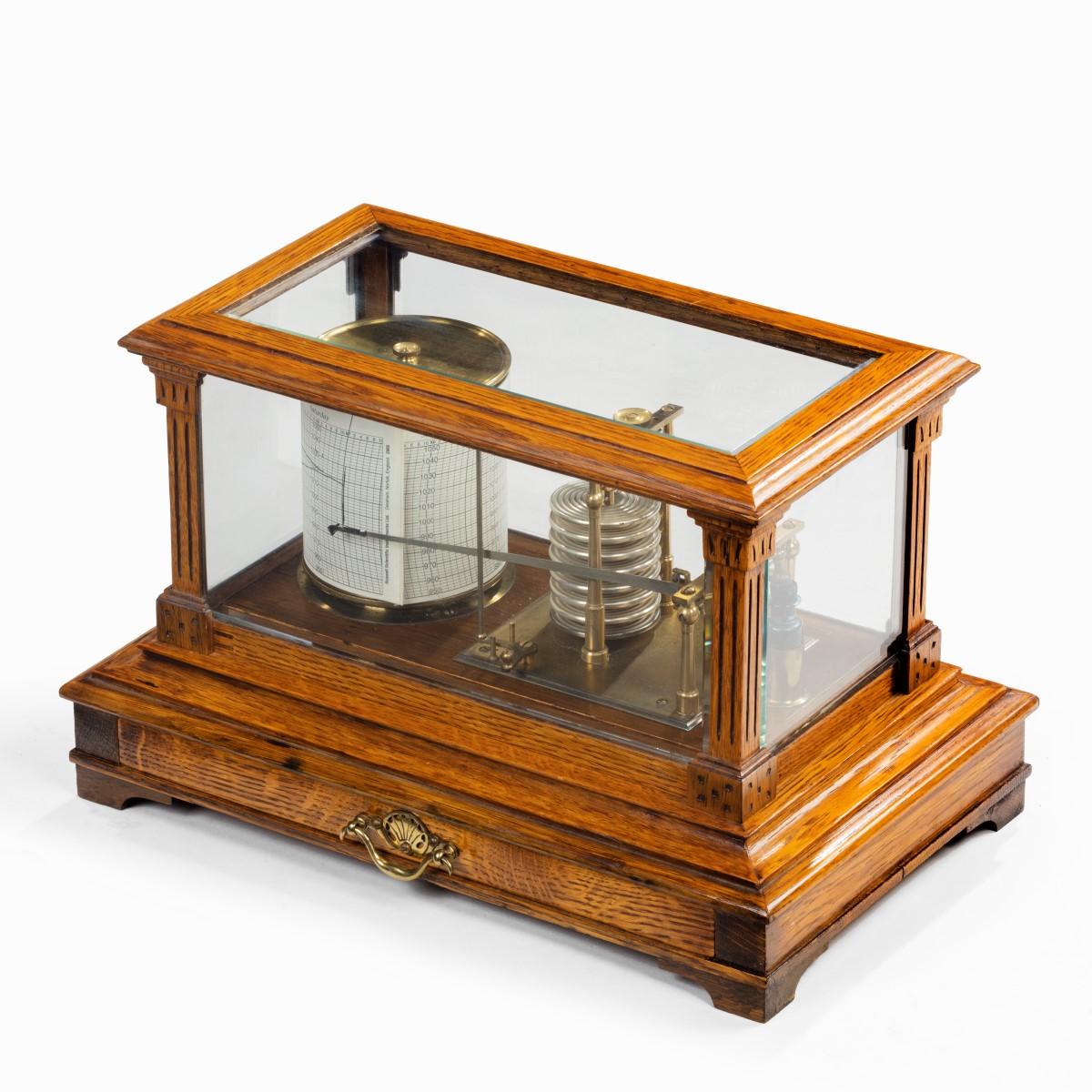 An Edwardian cased oak barograph with bevelled glass panels and a central chart drawer. Inscribed ‘Made by Short & Mason London, for A & N C S Westminster’.

A & N C S refers to the Army & Navy Co-operative Society Ltd., an army surplus department