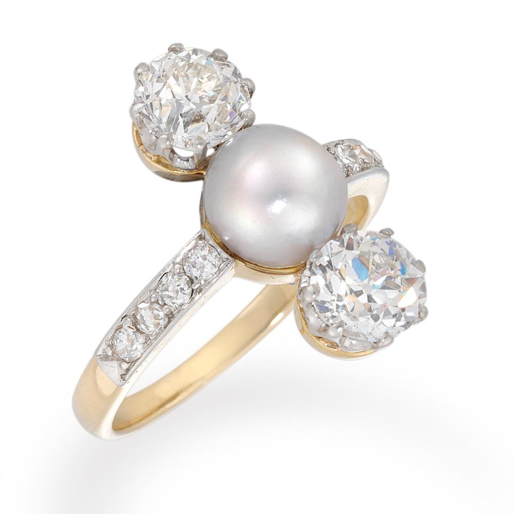 An Edwardian diamond and cultured pearl three-stone ring, the central cultured pearl, measuring approximately 6.85 mm diameter, set between two old brilliant-cut diamonds, weighing a total of 1.76cts, all vertical set to a gold open backed mount