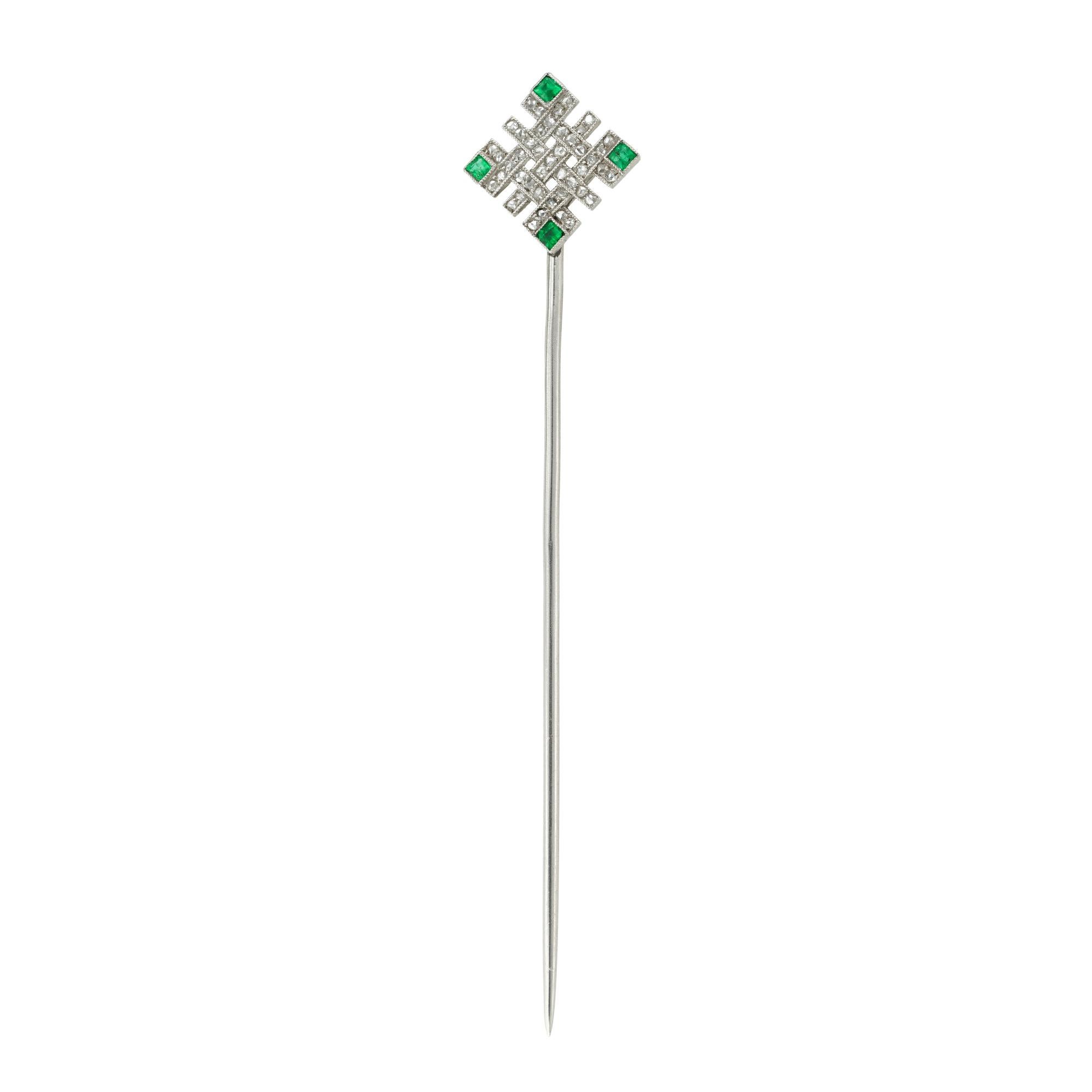 An Edwardian diamond and emerald stick-pin, the square shaped openwork panel consisting of six interwoven stripes finely millegrain-set with forty-five rose-cut diamonds, each corner set with a square-cut faceted emerald, all mounted in platinum