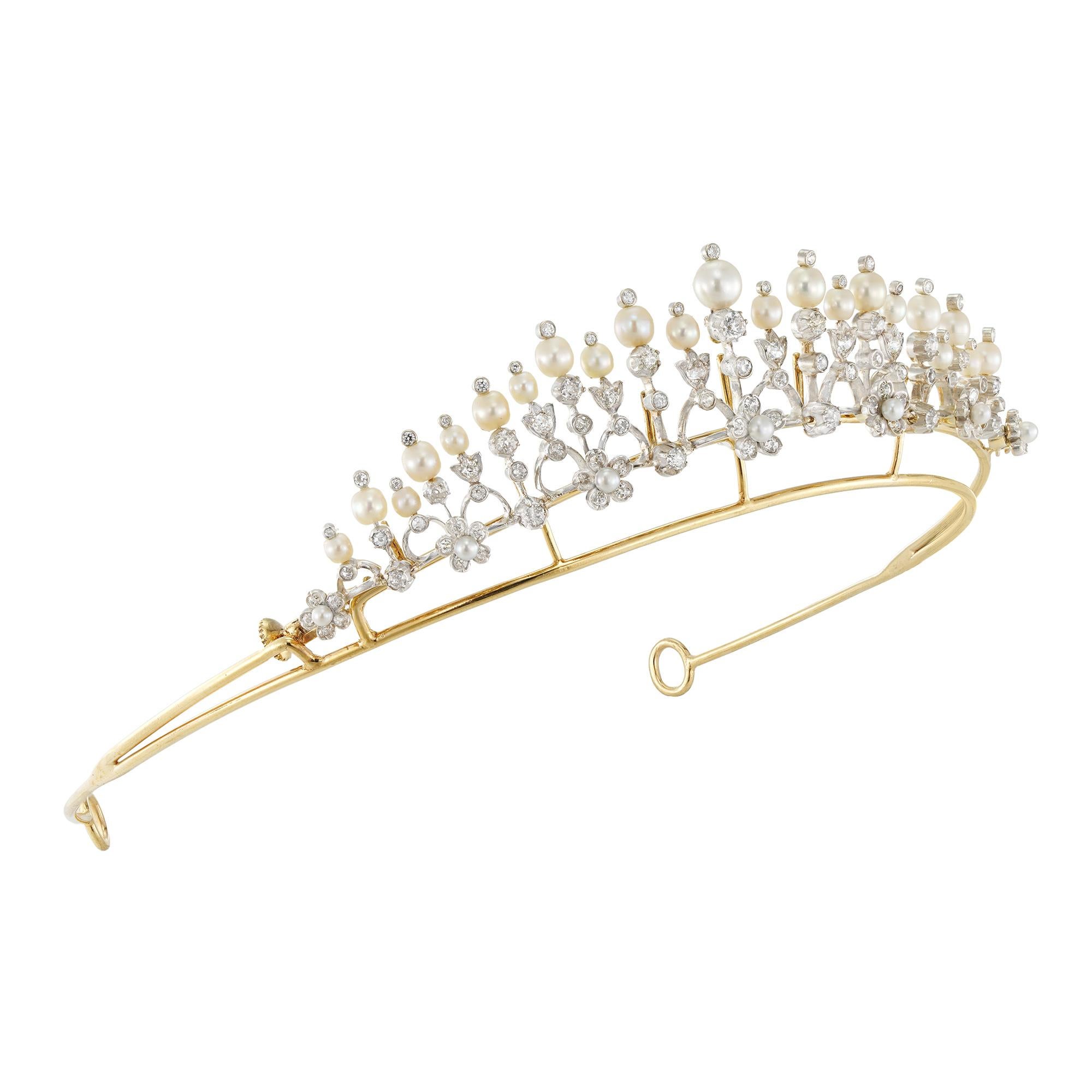An Edwardian diamond and pearl-set tiara/necklace, consisting of eleven knife-edge bars graduating from the centre, each embellished with old-cut diamonds in cut-down collet settings, connected with twelve arches with diamond-set foliate motifs,