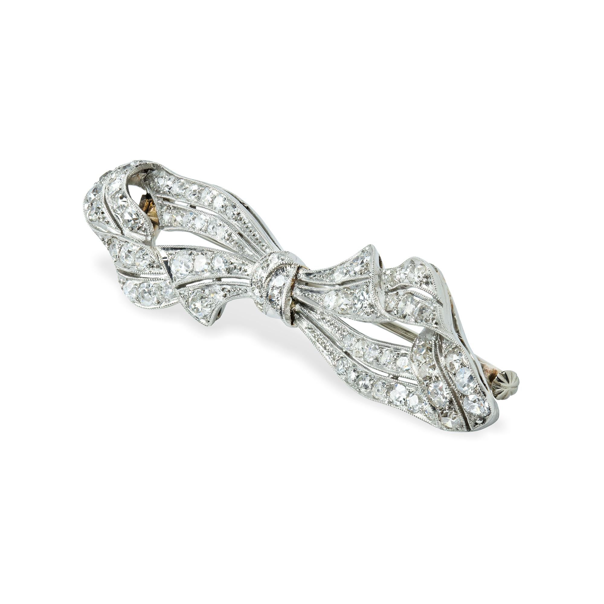 An Vintage diamond-set bow brooch, the old brilliant-cut diamonds old brilliant-cut diamonds estimated to weigh 3 carats in total, millegrain-set in platinum openwork mount in the form of a bow, with yellow gold pin fitting, bearing Austrian