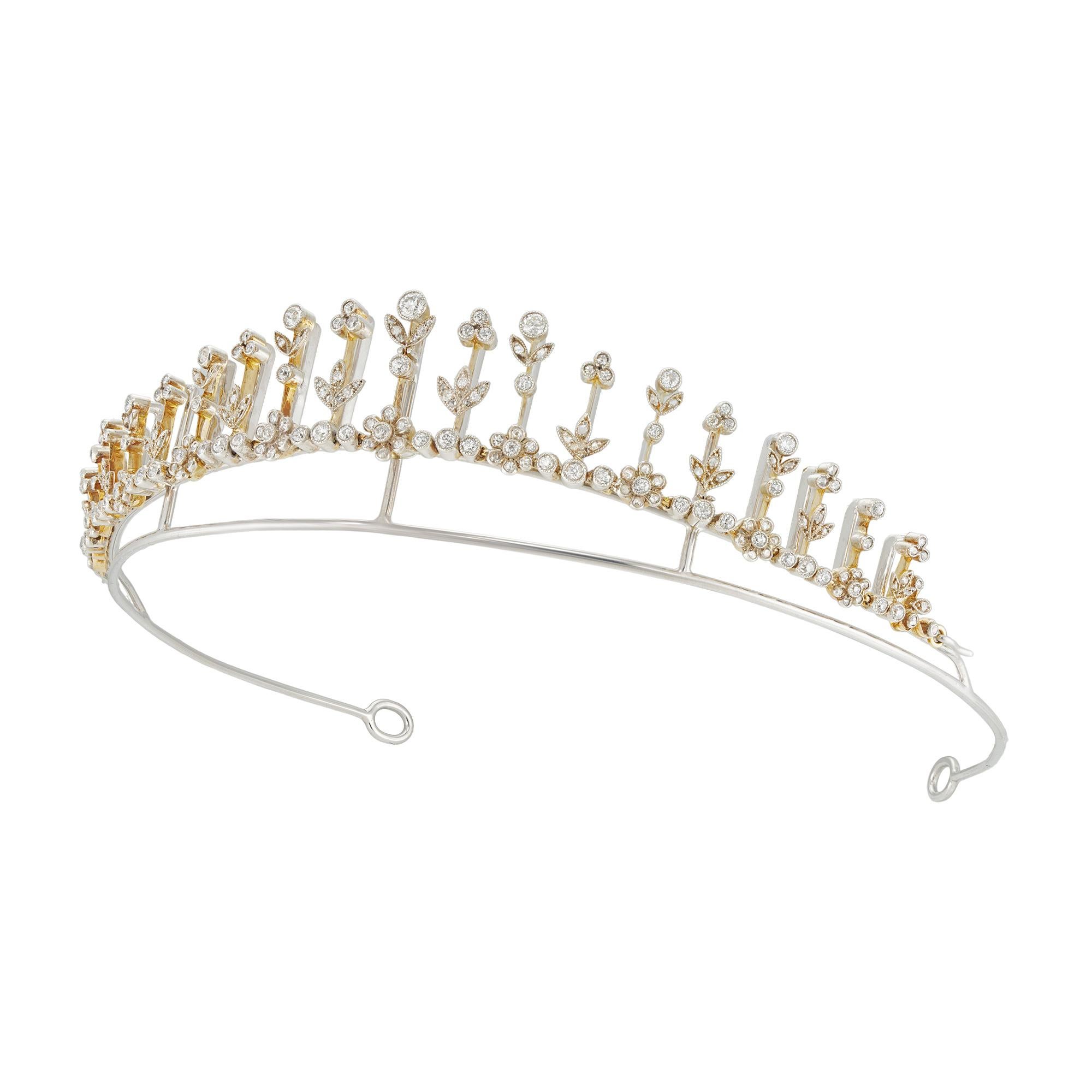 An Edwardian diamond-set tiara/necklace, in the form of a fringe consisting of nineteen knife-edge bars embellished with single diamond collets and diamond-set foliate motifs, the base set with nine diamond-set flower clusters each connected with