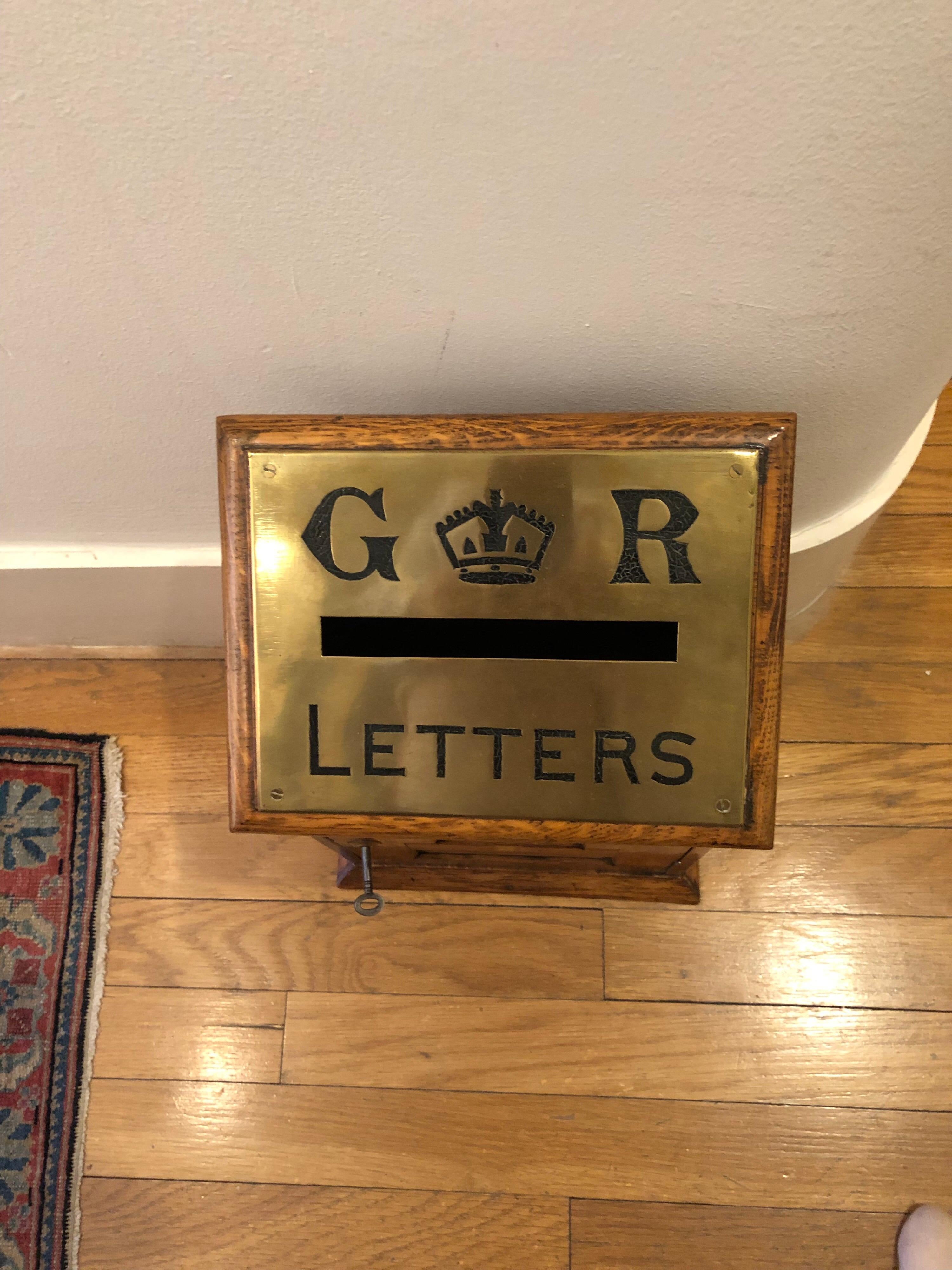 La boîte en chêne avec une plaque en laiton Royal Georgian sur le dessus, les heures de ramassage sur le devant. La serrure et la clé en laiton fixées à la porte.