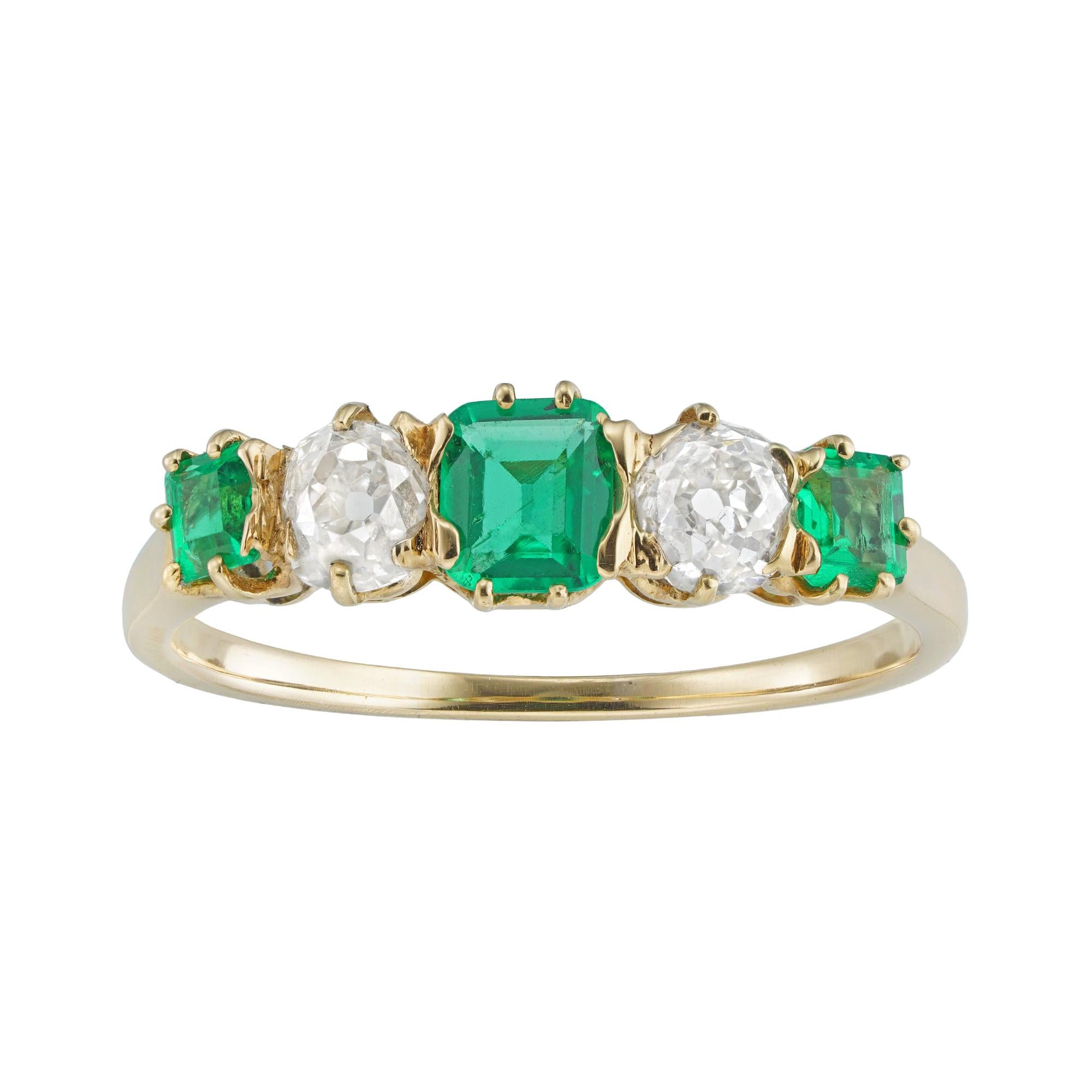 An Edwardian emerald and diamond five-stone ring, the three octagonal-cut faceted emeralds estimated to weigh 0.35 carats in total, the two old European-cut diamonds estimated to weigh a further total of 0.4 carats, all claw-set in yellow gold