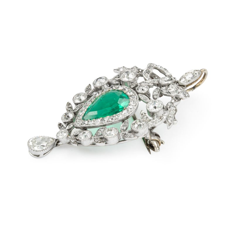 An Edwardian emerald and diamond pendant/brooch, the pear-shaped emerald, weighing approximately 2.20 carats, accompanied by GCS Report no:5777-8959 stating to be of Colombian origin with minor enhancement, surrounded by twenty two old brilliant-cut