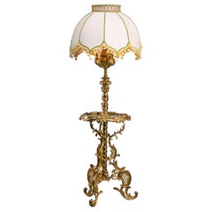 Un tavolo da tavolo con lampada standard in bronzo dorato di epoca edoardiana