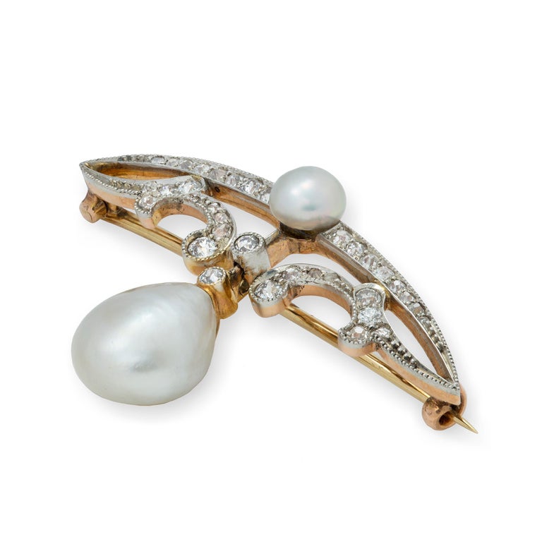 An Edwardian natural pearl and diamond brooch, the two natural pearls accompanied by GCS certificate number  stating the pearls to be natural of saltwater origin, the larger pearl suspending from a diamond-set scrolled designed bar with a smaller