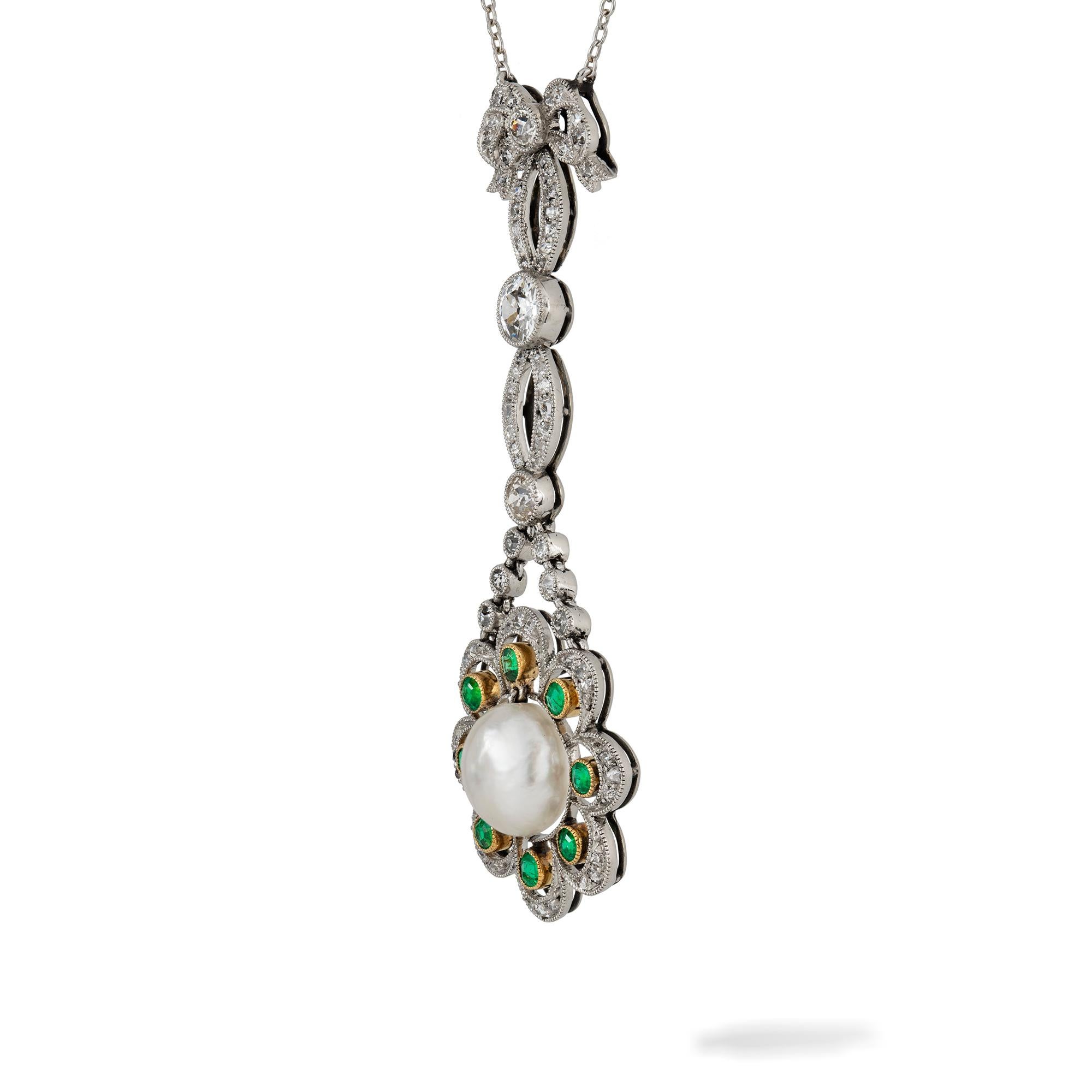 An Edwardian natural pearl, diamond and emerald pendant, to the centre a pearl accompanied by GCS Report stating to be natural of Saltwater origin, within a diamond and emerald encrusted cluster of openwork scalloped-sedge design, suspended by a